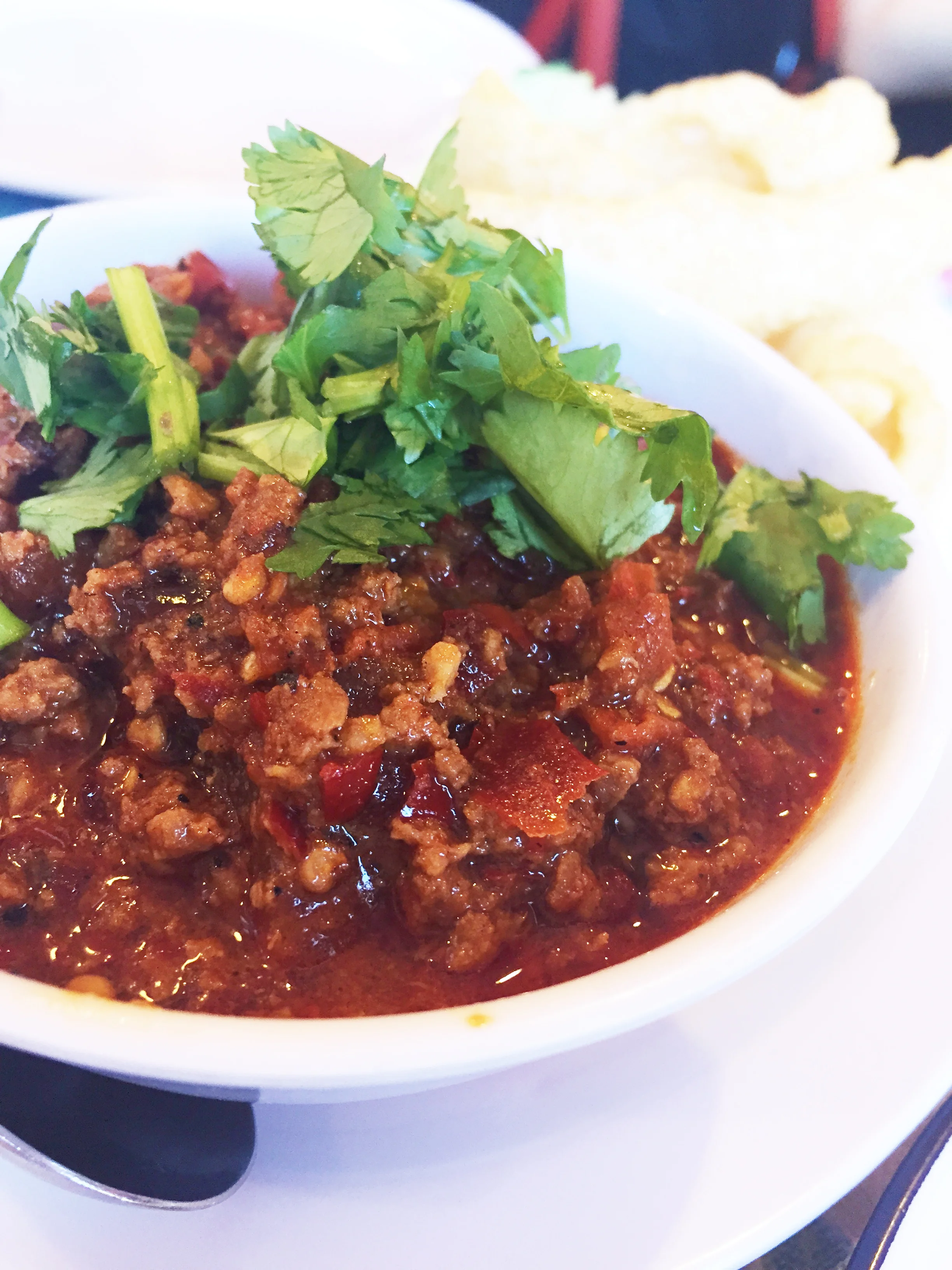 Nam Prik Ong - a homemade ground pork "ragout" cooked down with gapi, cherry tomatoes, and roasted chile, served with pork rinds.