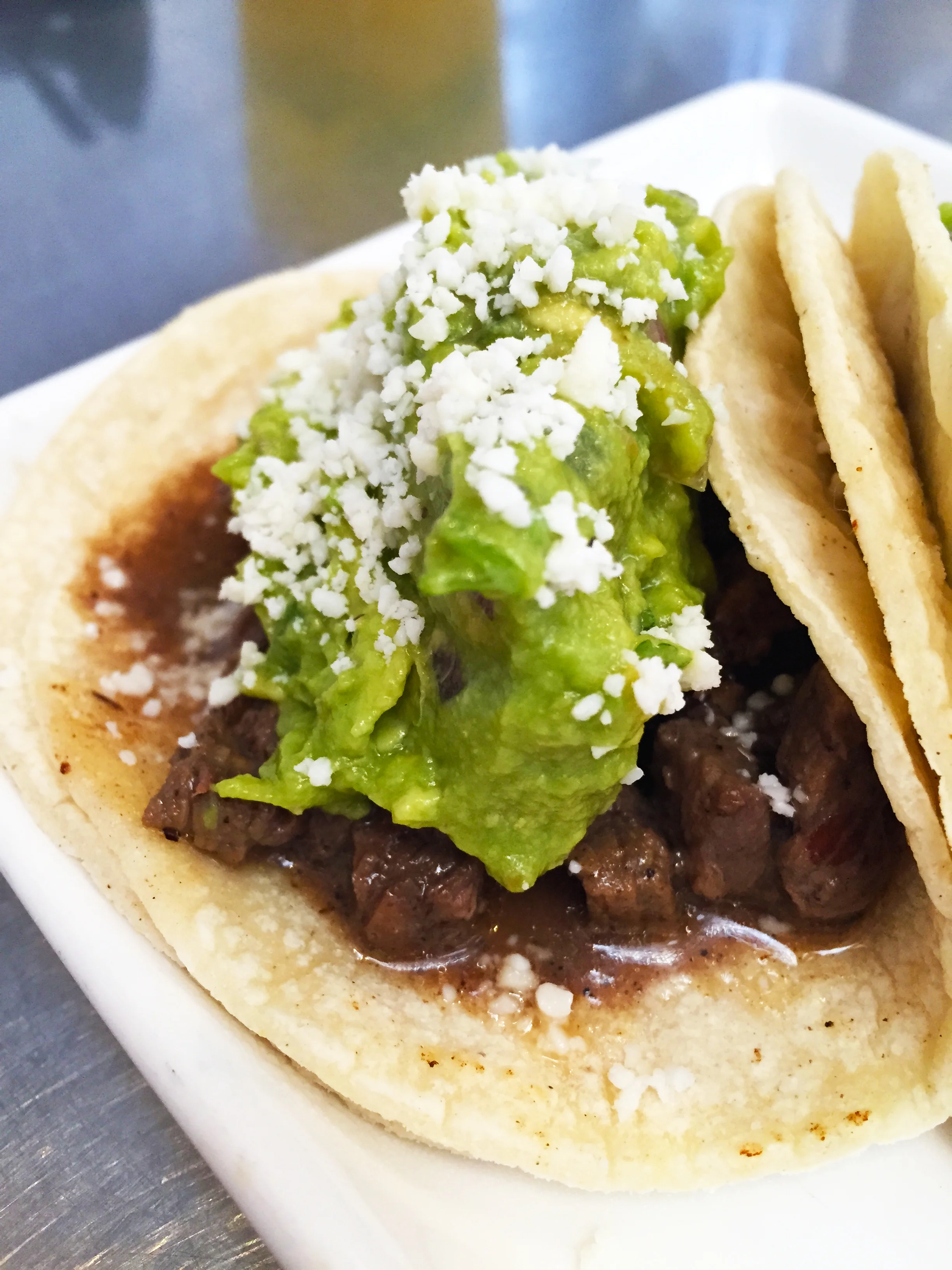Signature Taco with marinated top sirloin steak, guacamole, and cotija cheese.