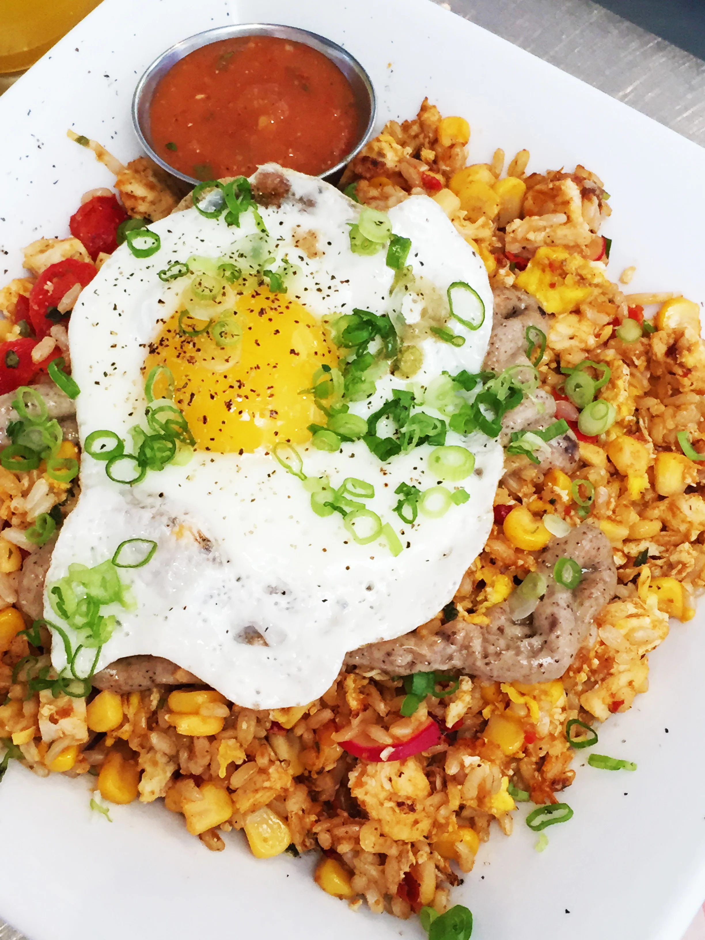 Nasi Goreng - Indonesian fried rice with garlic aioli and corn salad topped off with green onions and a sunny side egg (and optional chicken).