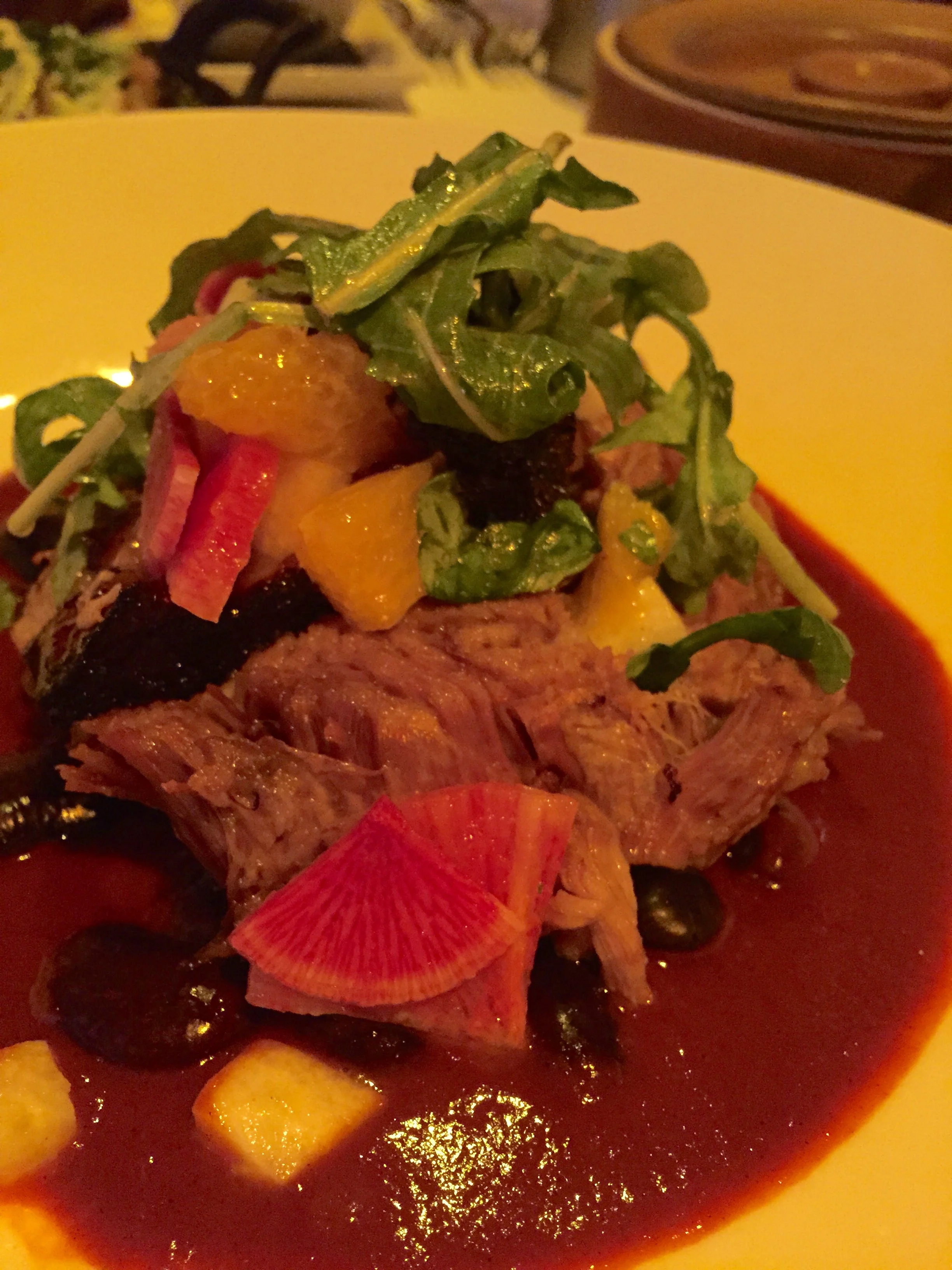 Carnitas in Red Chile Guajillo with slow-cooked Compart Farms duroc pork, orange-guajillo chile sauce, ayocote beans, and jícama-citrus salad.