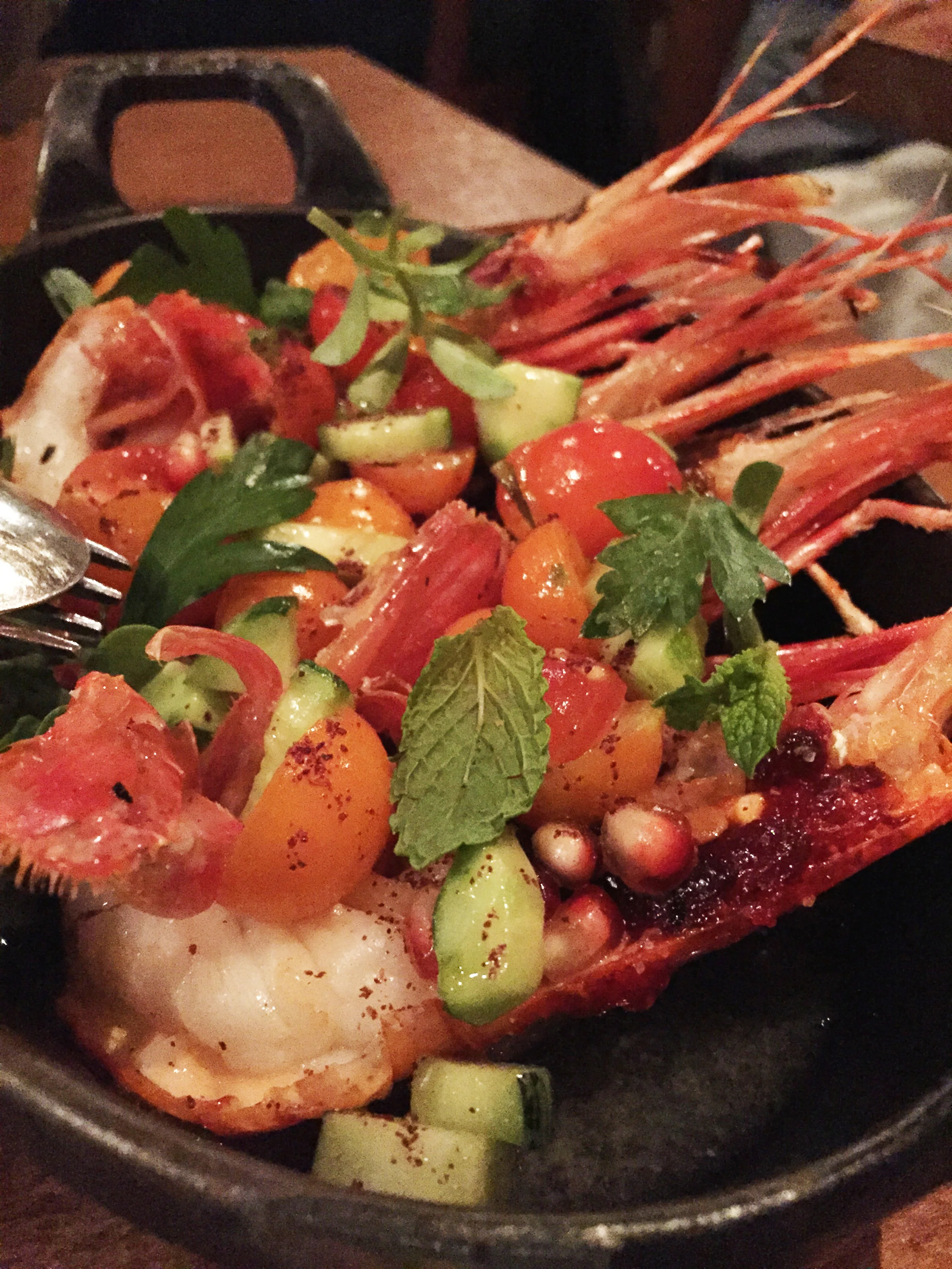 Grilled Santa Barbara Prawns with charred eggplant, cherry tomatoes, cucumbers, and sumac.