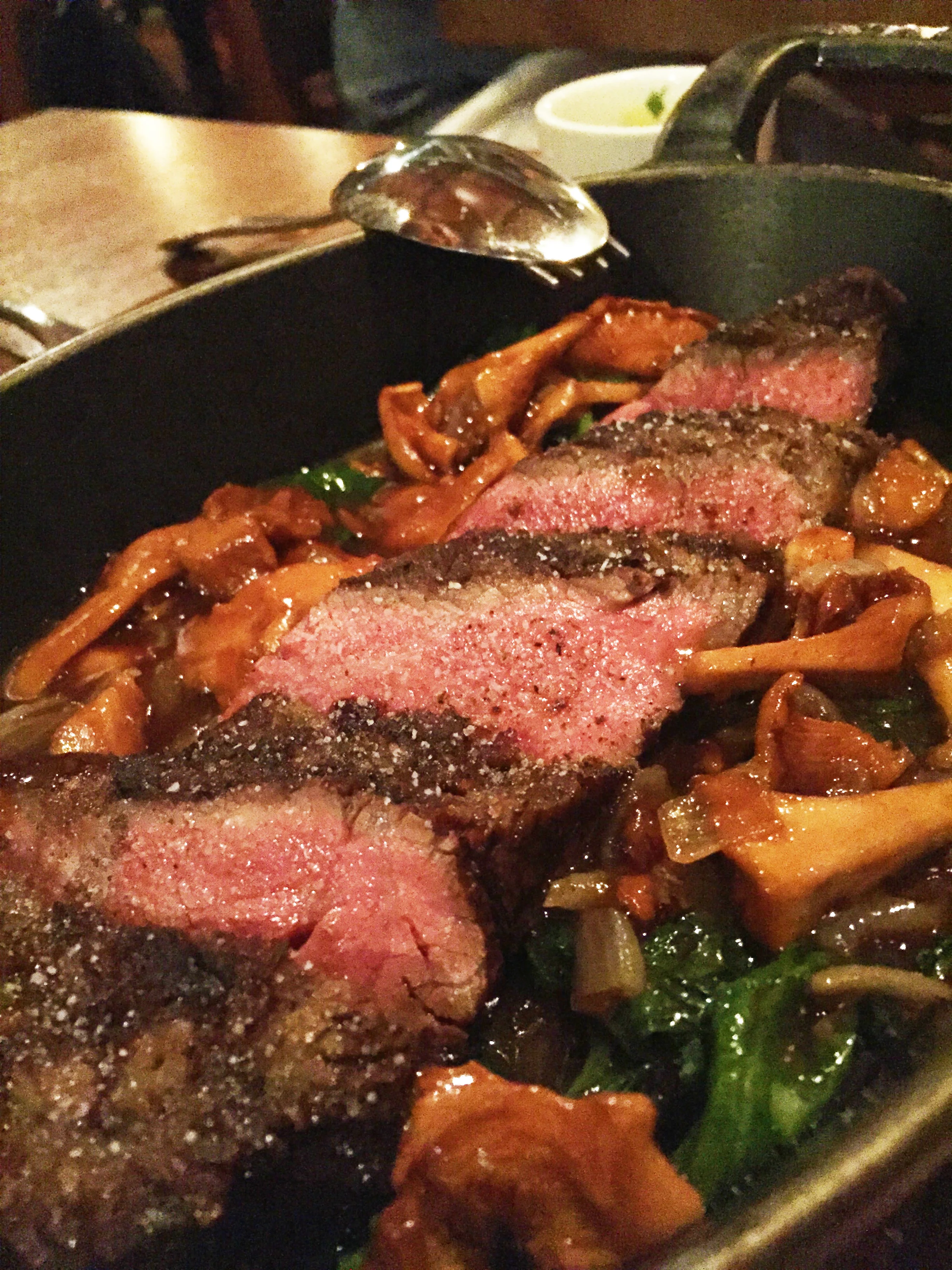 Prime Dry-Aged Beef Rib Eye with chanterelle mushrooms and baby spinach.