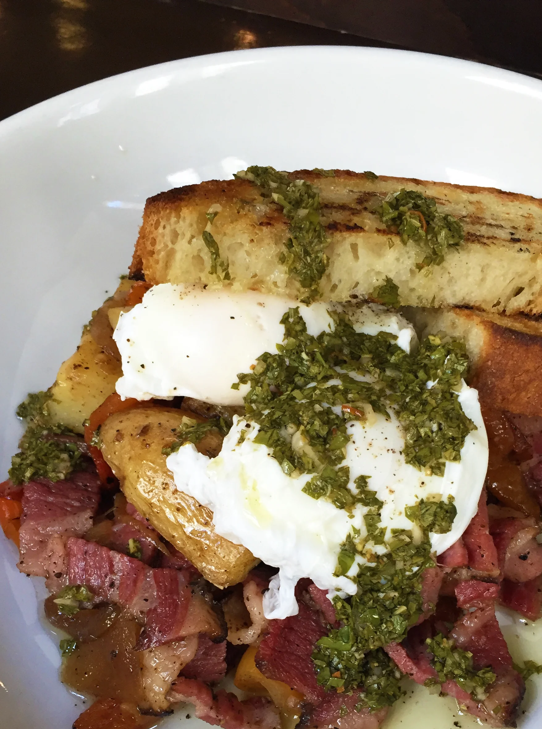 Pastrami Hash with fingerling potatoes, caramelized onions, peppers, roasted squash, salsa verde, and poached eggs.