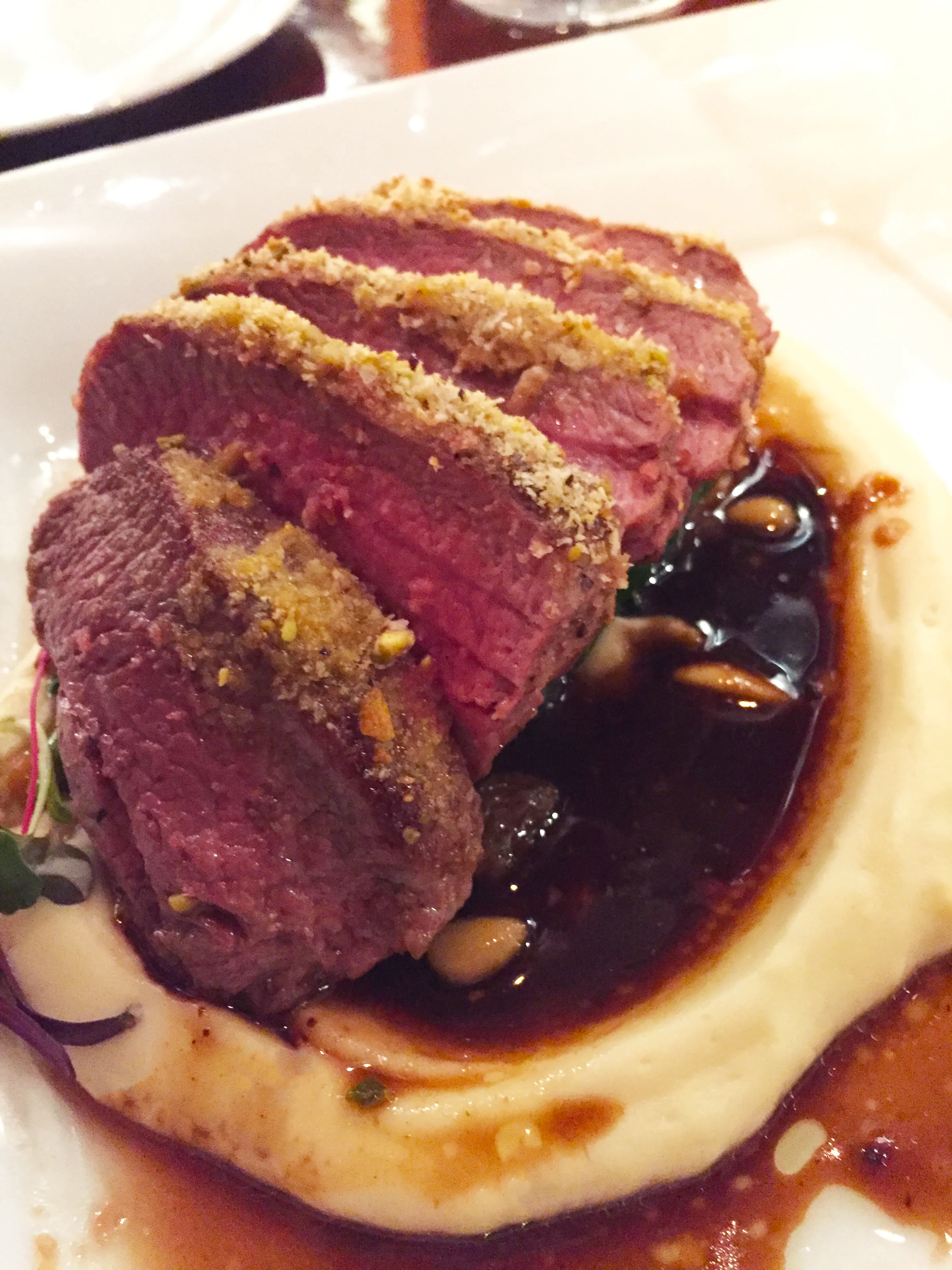 Colorado Lamb Loin with pistachio crust, celery root puree, catalan spinach, and black garlic jus.