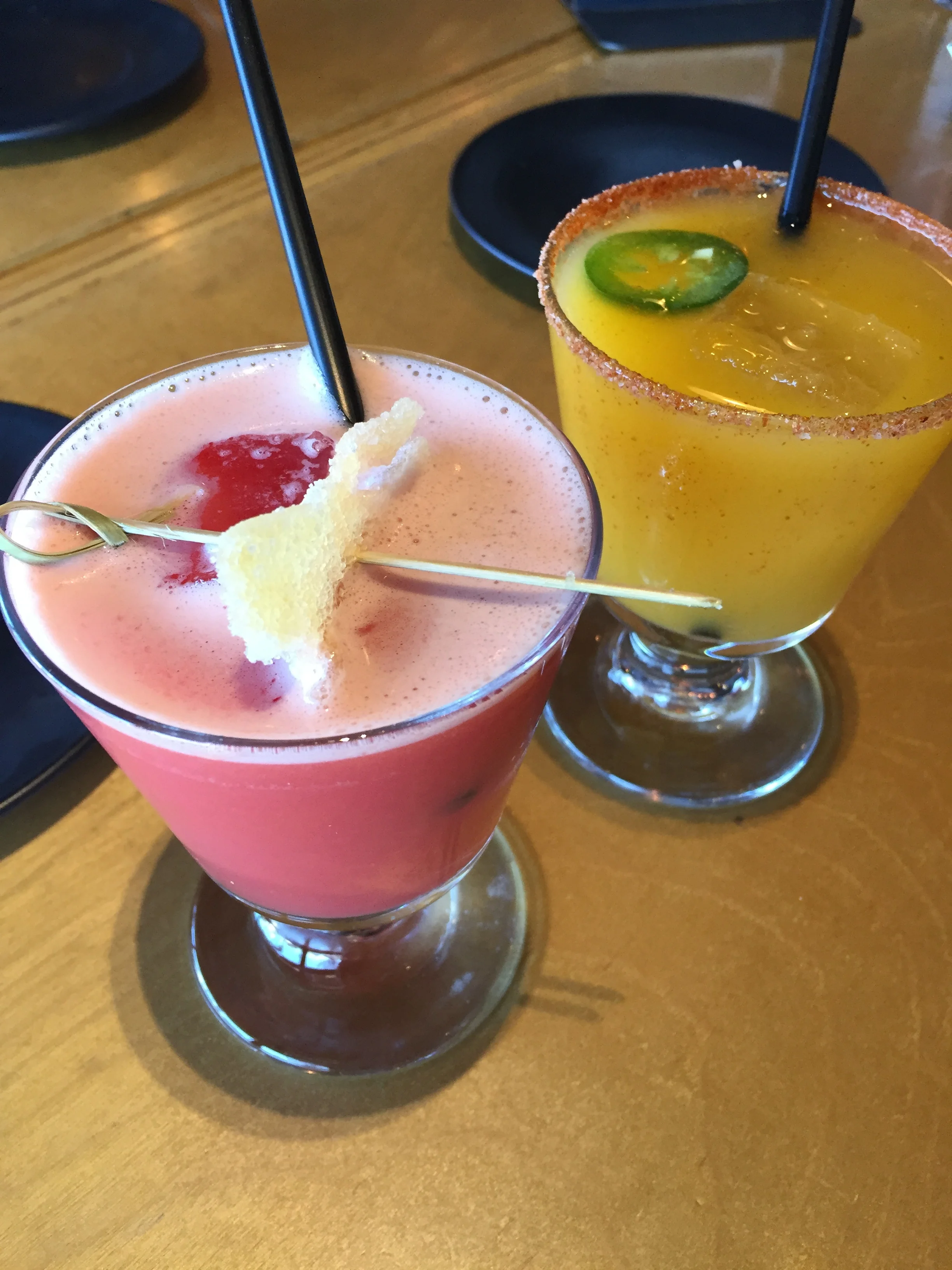 (front) GINGER GRANT - pisco, blood orange, sake, aperol, ginger . (back) TROPIC THUNDER - jalapeno infused tito's vodka, mango, lemon juice, sugar.