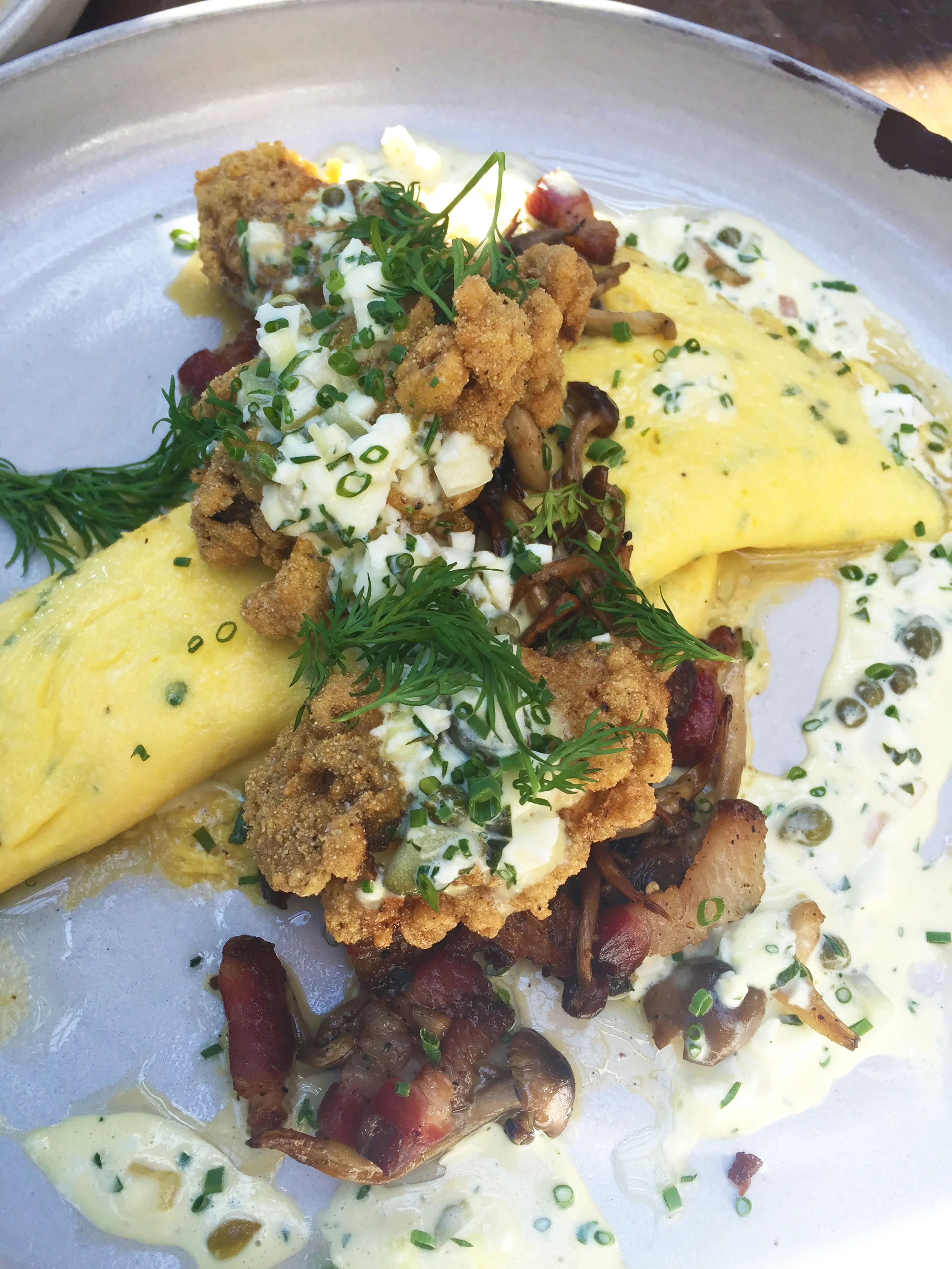 Fried Oyster Omelet with bacon, mushrooms, gribiche, and herbs.