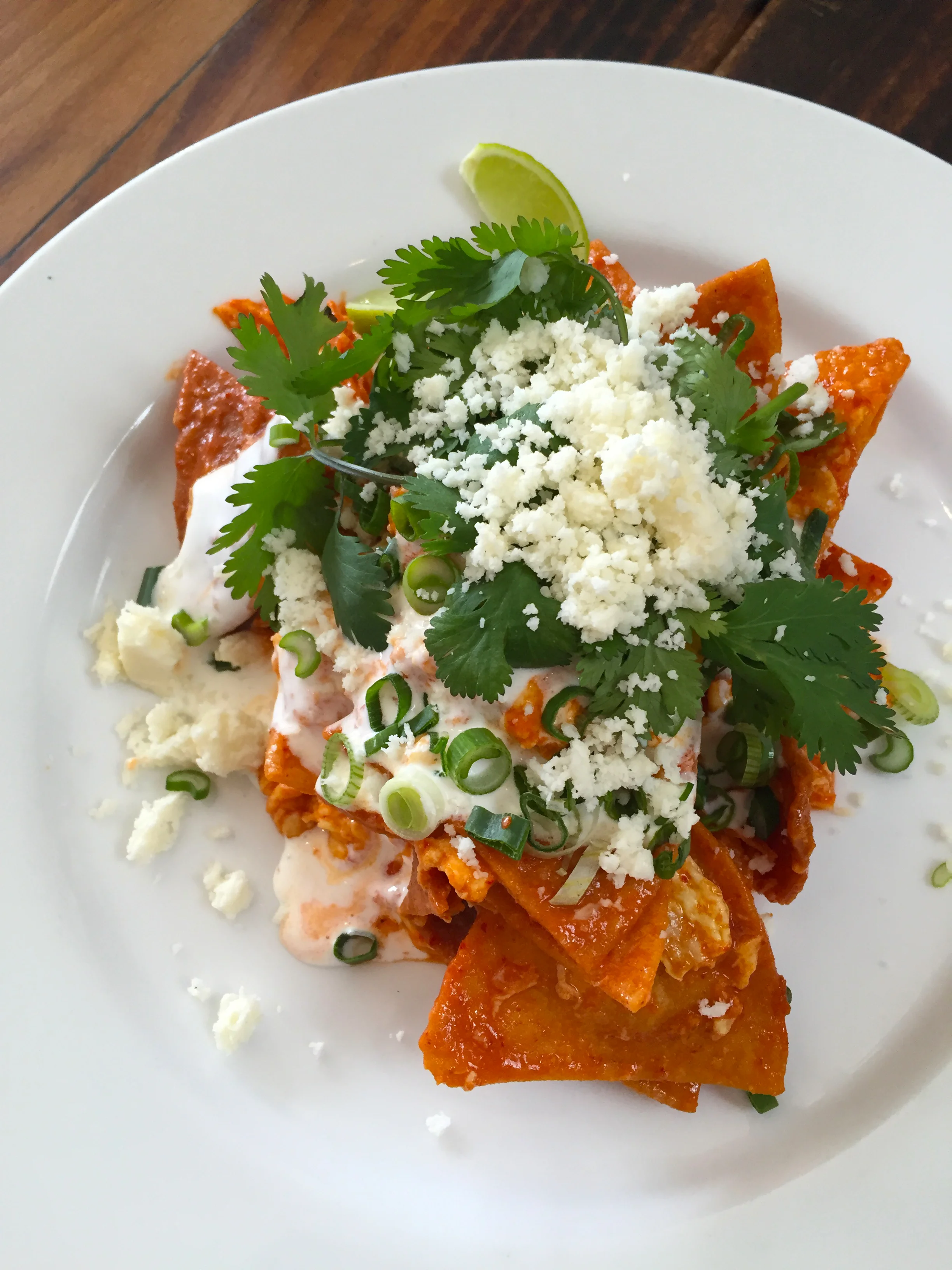 Raymundo's chilaquiles with Mexican sour cream, cilantro, scallion, and cotija.