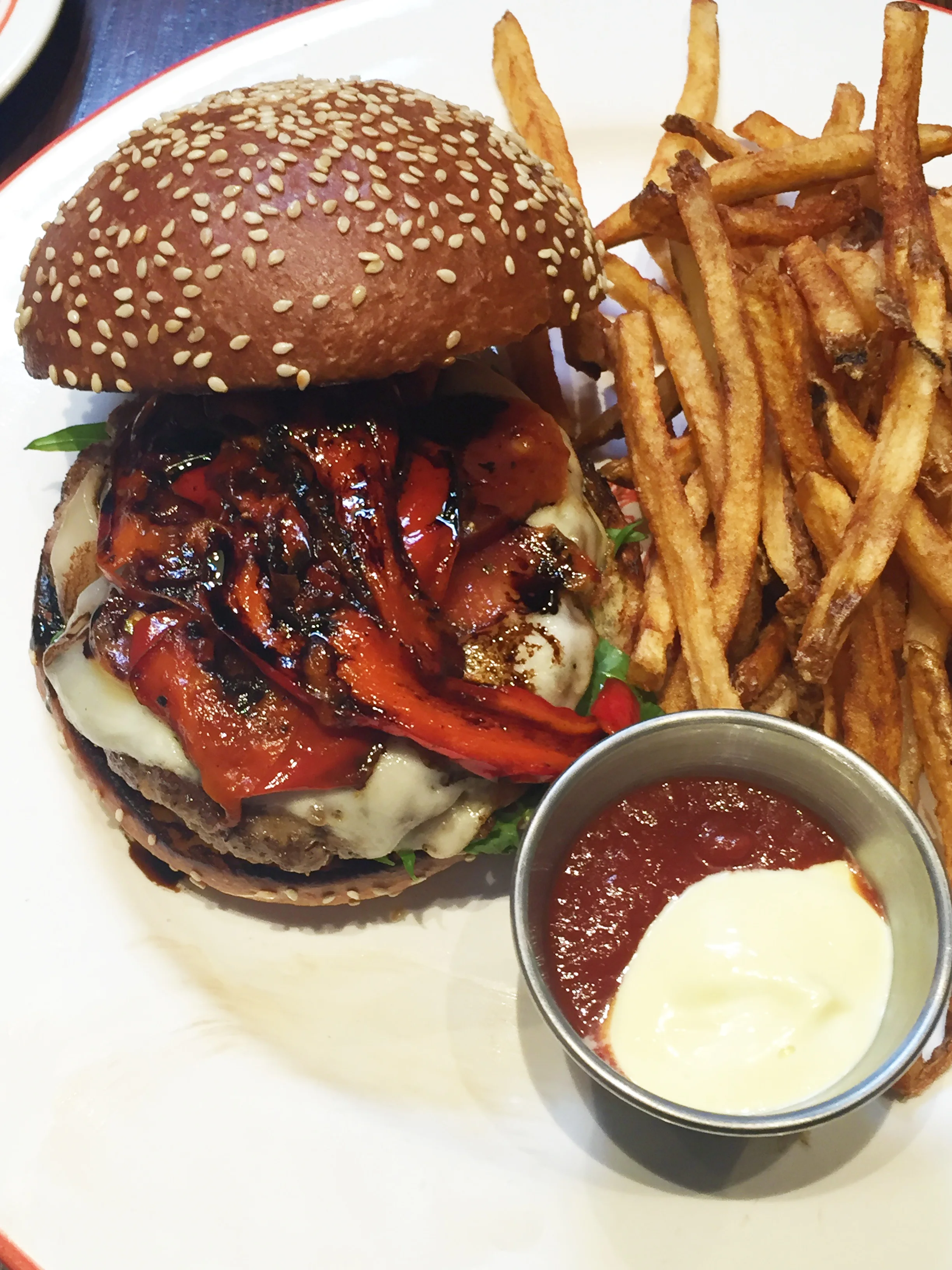 Pepperoni Burger with pork patty, Belcampo by Batali pepperoni, mozzarella, aioli, roasted red bell peppers and balsamic reduction on Bread Bar Brioche & fries.