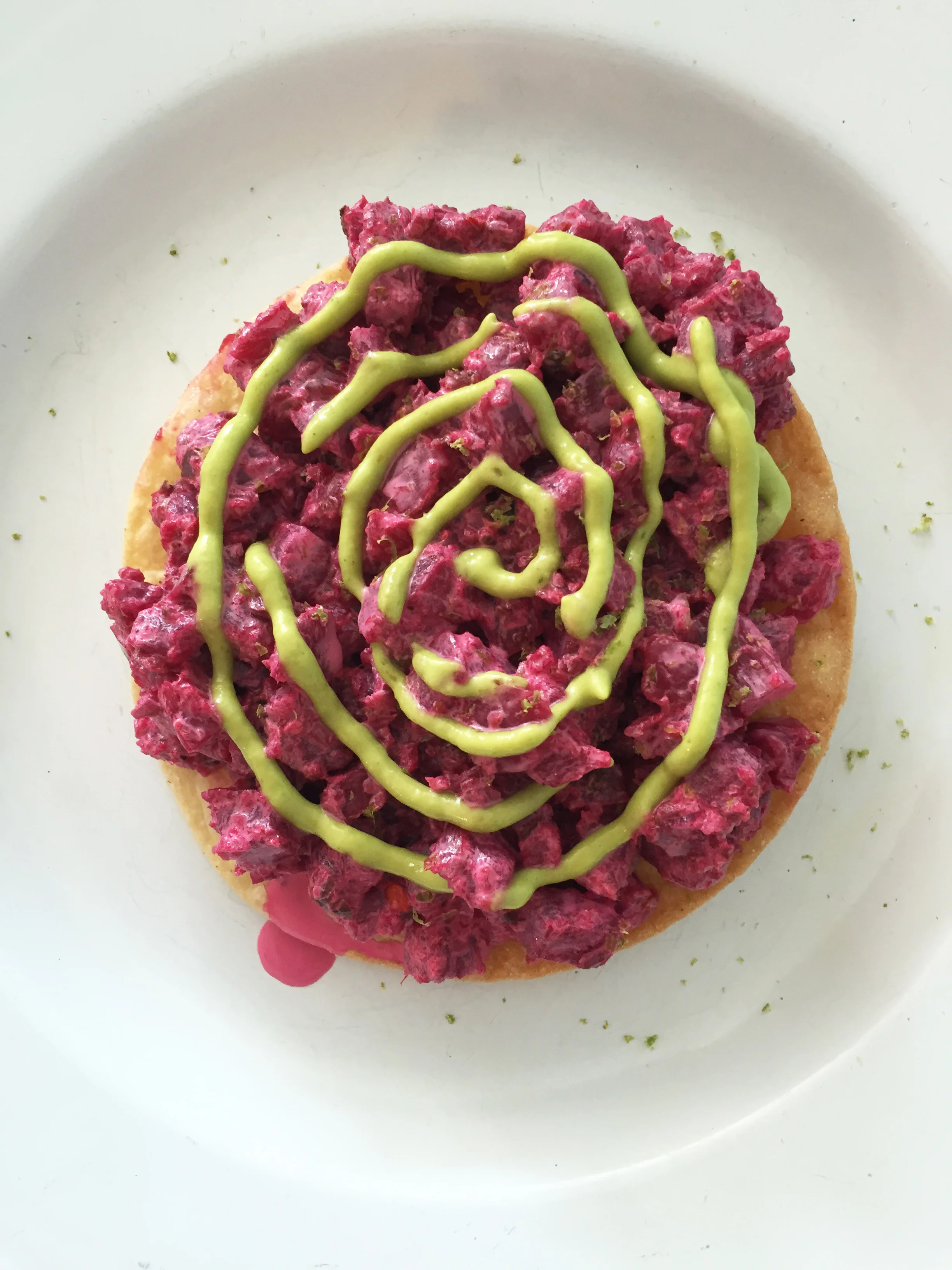 Beet tartare tostada with cornichon, lime, and avocado crema.
