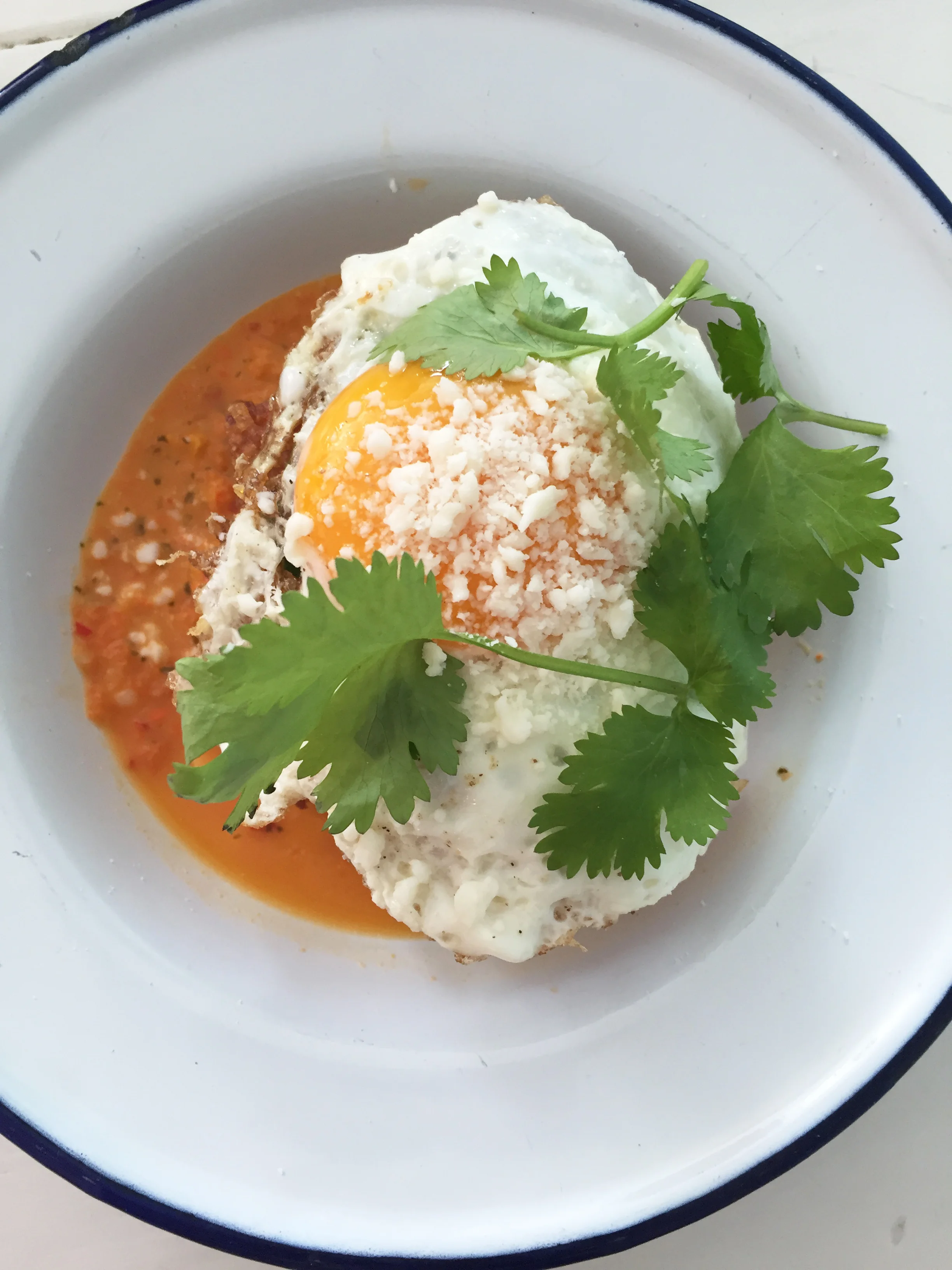 Crispy hash brown chilaquiles with sunny side up egg, cotija, and salsa macho.