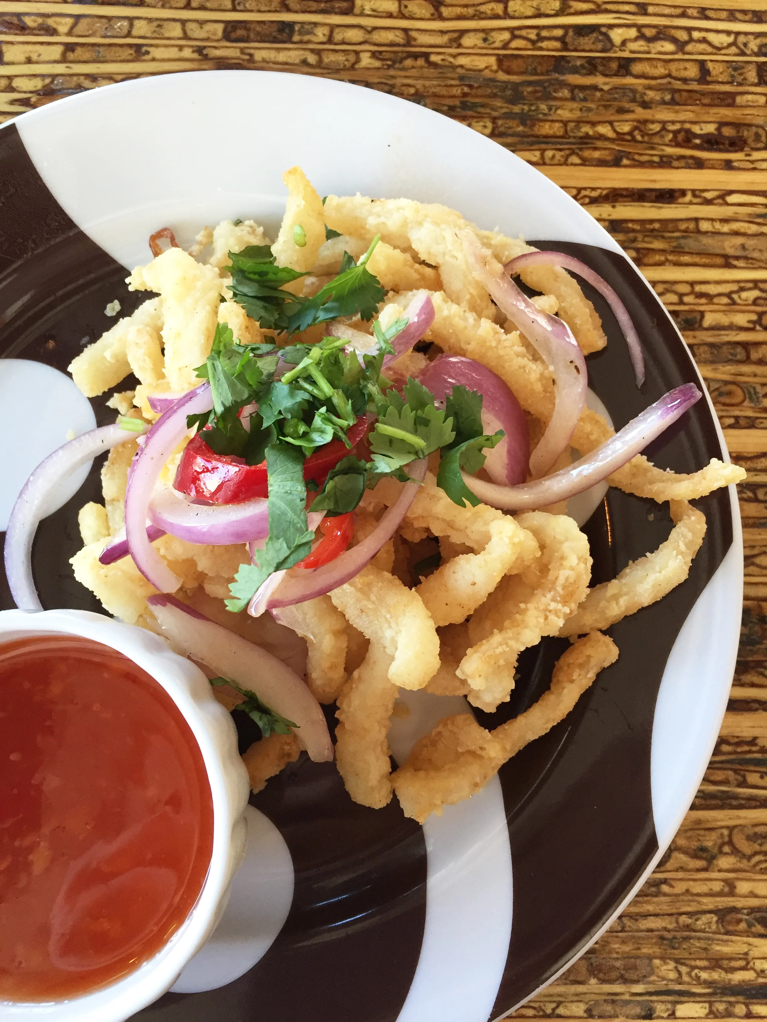 Crispy Calamari with sweet salt, pepper, grilled onion, cilantro, and chilies.