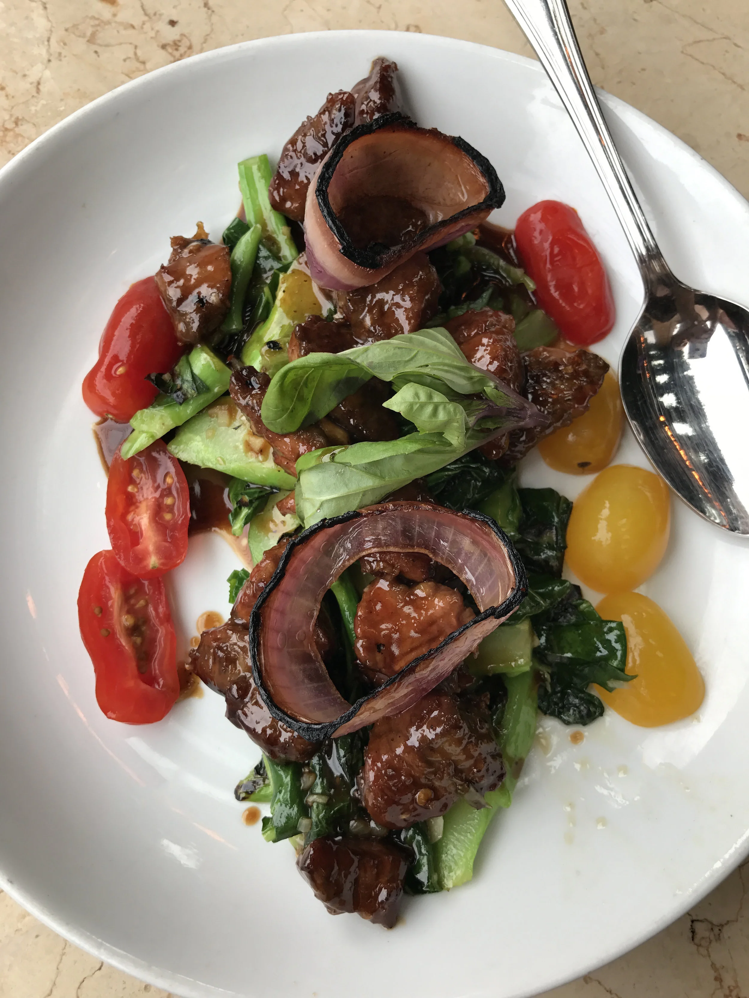 Bo Luc Loc - Shaken Beef with cubed filet mignon, gai lan, charred red onions, garlic, tomatoes, and Thai basil