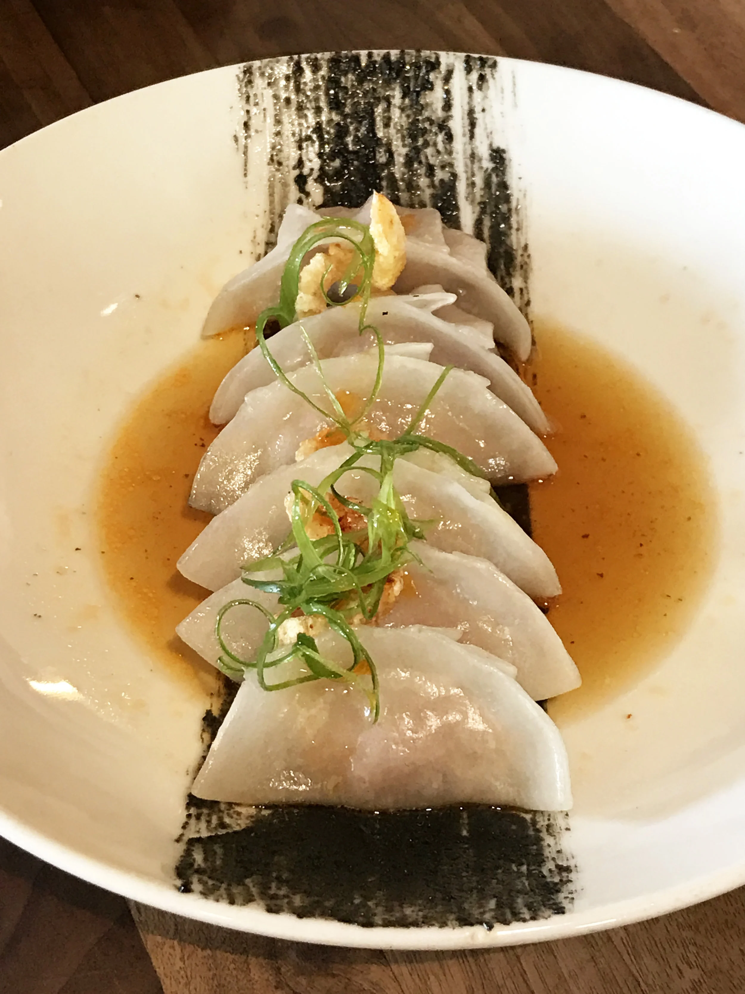 House-made pork and shrimp dumplings, citrus ponzu, chili oil, and chicharron