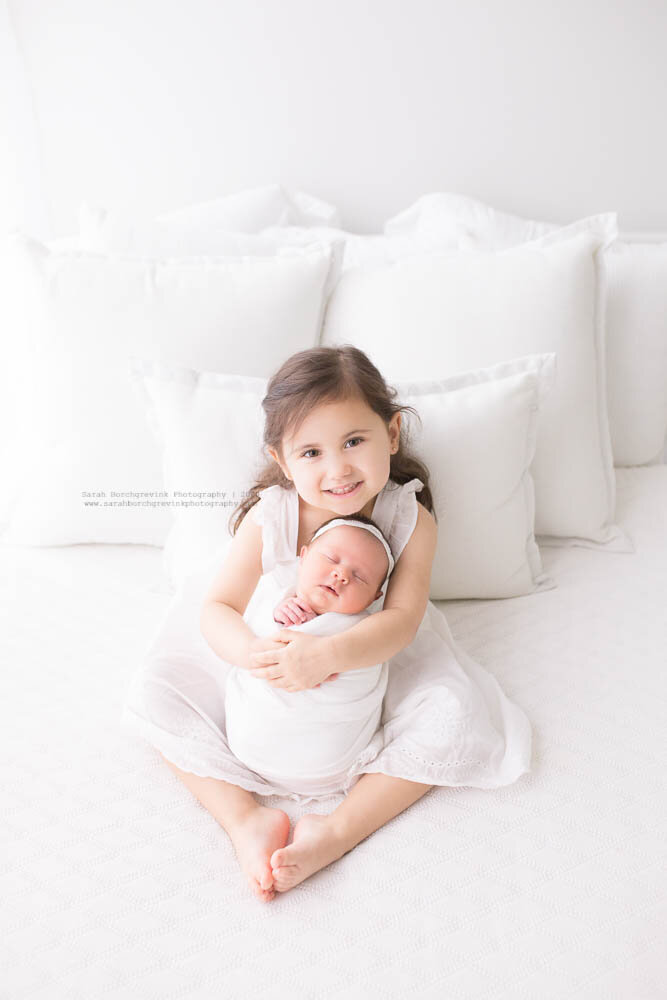 Sibling Poses with New Sister