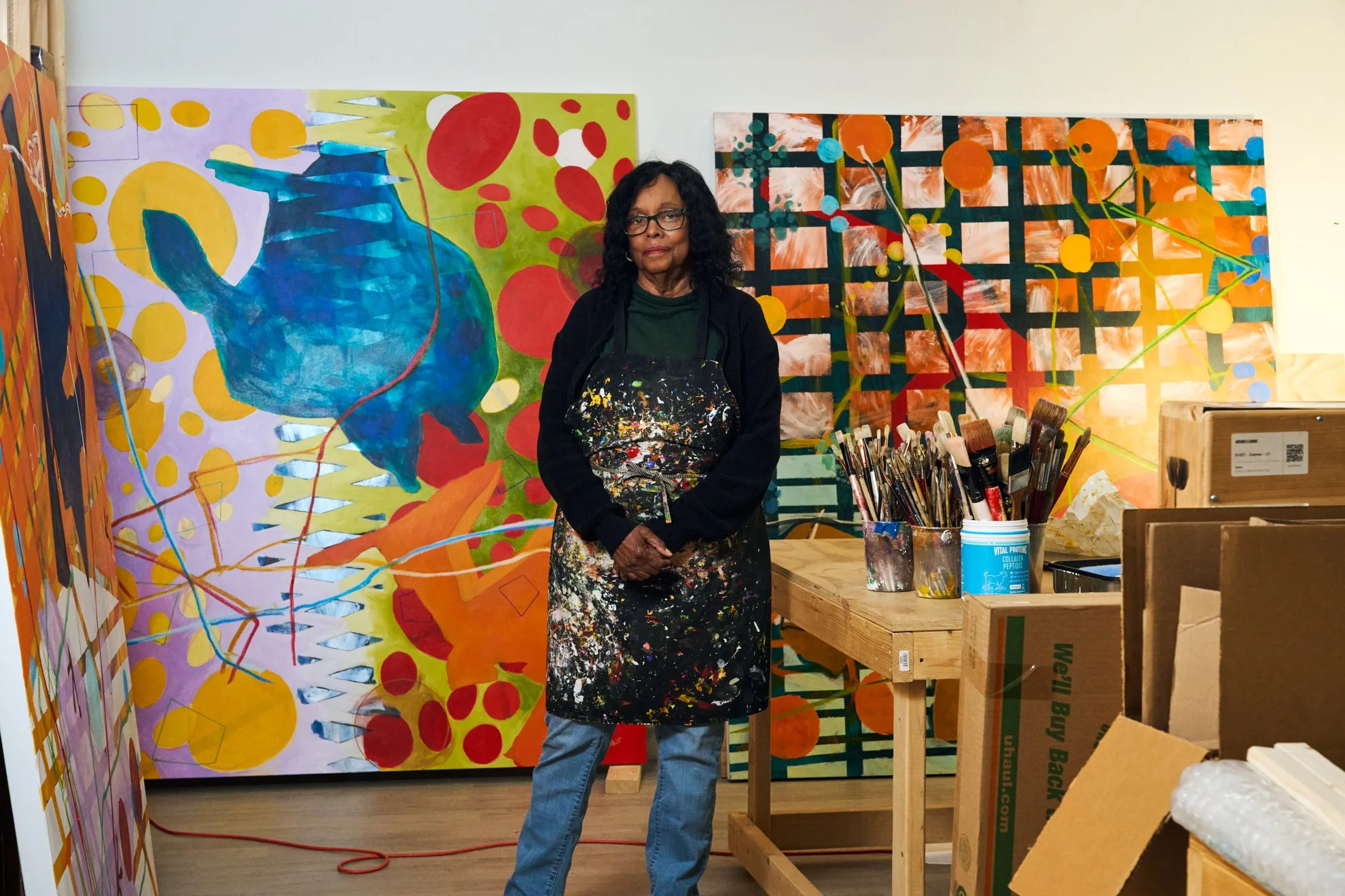 Editorial portrait of painter Cynthia Hawkins in her studio before her vivid abstract paintings, photographed by Christopher Garcia Valle