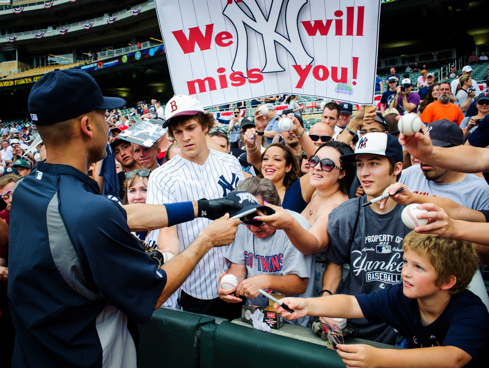 Derek Jeter #2 of the New York Yankees signs autographs for fans before the game against the Minnesota Twins on July 6, 2014 at Target Field in Minneapolis, Minnesota.  (Photo by Hannah Foslien/Getty Images)  