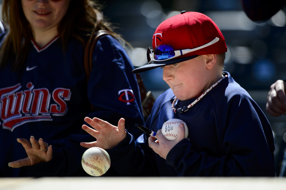  A young fan catches a ball thrown by a player for the Minnesota Twins during batting practice before the home opening game against the Kansas City Royals on April 13, 2015 at Target Field in Minneapolis, Minnesota.   (Photo by Hannah Foslien/Getty I