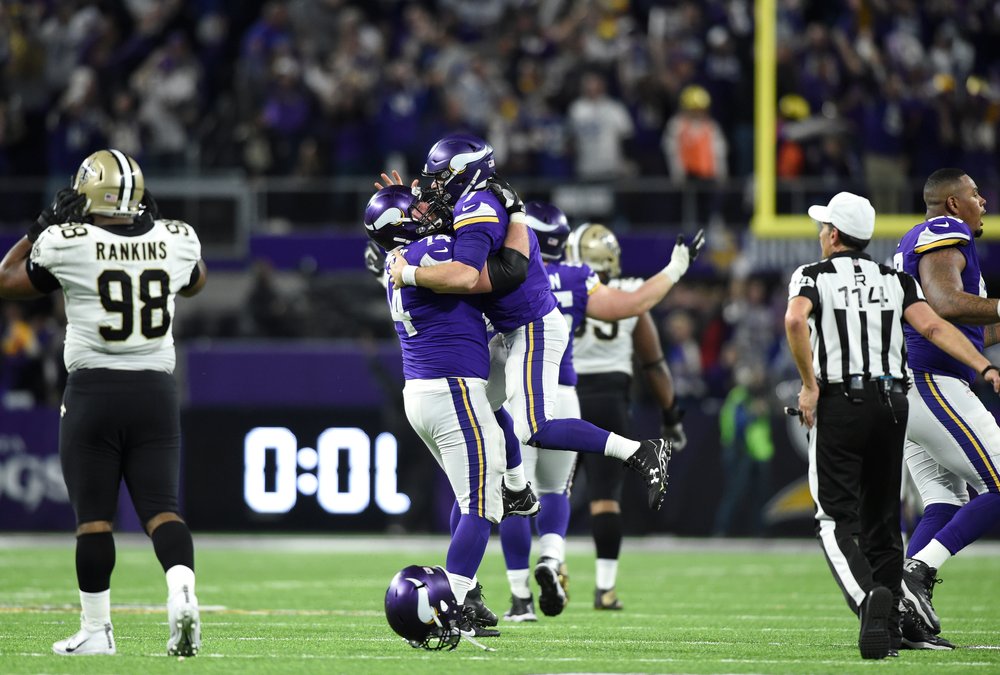  Case Keenum #7 of the Minnesota Vikings celebrates with teammate Mike Remmers #74 after completing a 61-yard touchdown pass to win the NFC Divisional Playoff game against the New Orleans Saints on January 14, 2018 at U.S. Bank Stadium in Minneapolis