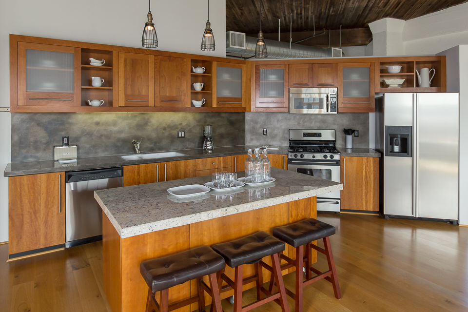 One of the easiest kitchens to shoot, ever. 2 layer composite - 1 flash with STU camera left with kitchen lights ON. 1, same setup, with kitchen lights OFF! I used the lights off image as the base layer so there is no reflection from the lights on the kitchen counters, then masked in the lights above the island and the under-cabinet lighting to taste.
