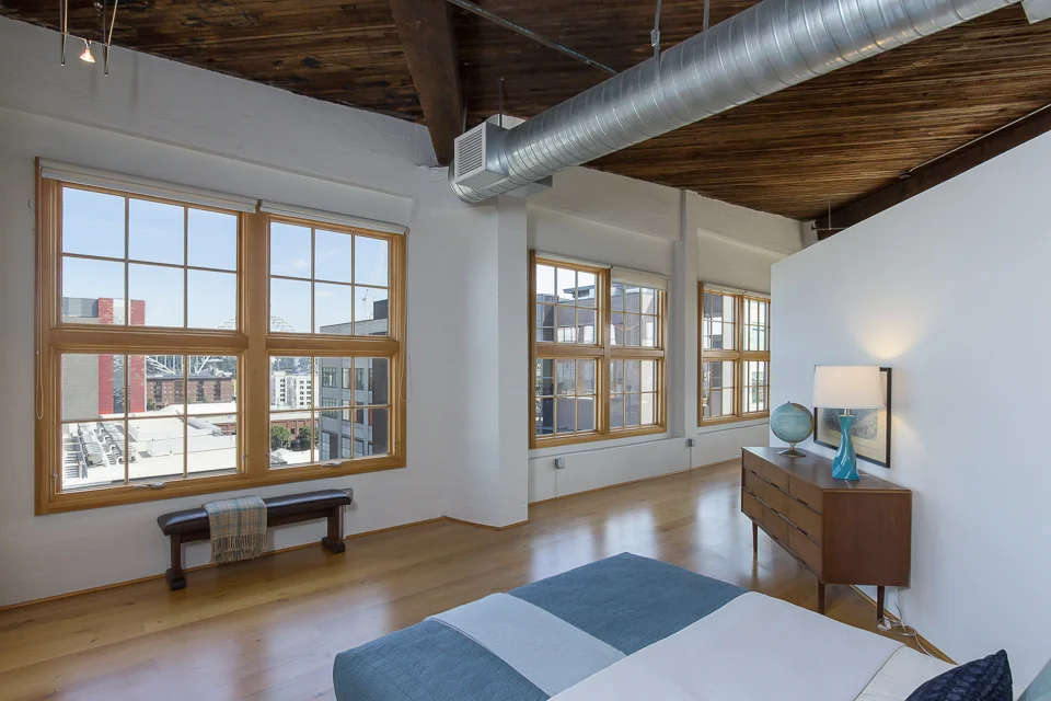 4 image composite. 1 ambient, 1 flashed (flashes bounced off white walls camera left and above the bed camera right. 2 different exposures for the view due to variation in lighting outside (due to the different building heights and sun location).