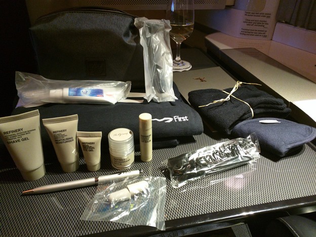 A set of pajamas, a toothbrush and toothpaste, a razor, a pen, ear plugs, a scented eye mask, socks, a handful of lotions and creams, and a travel bag