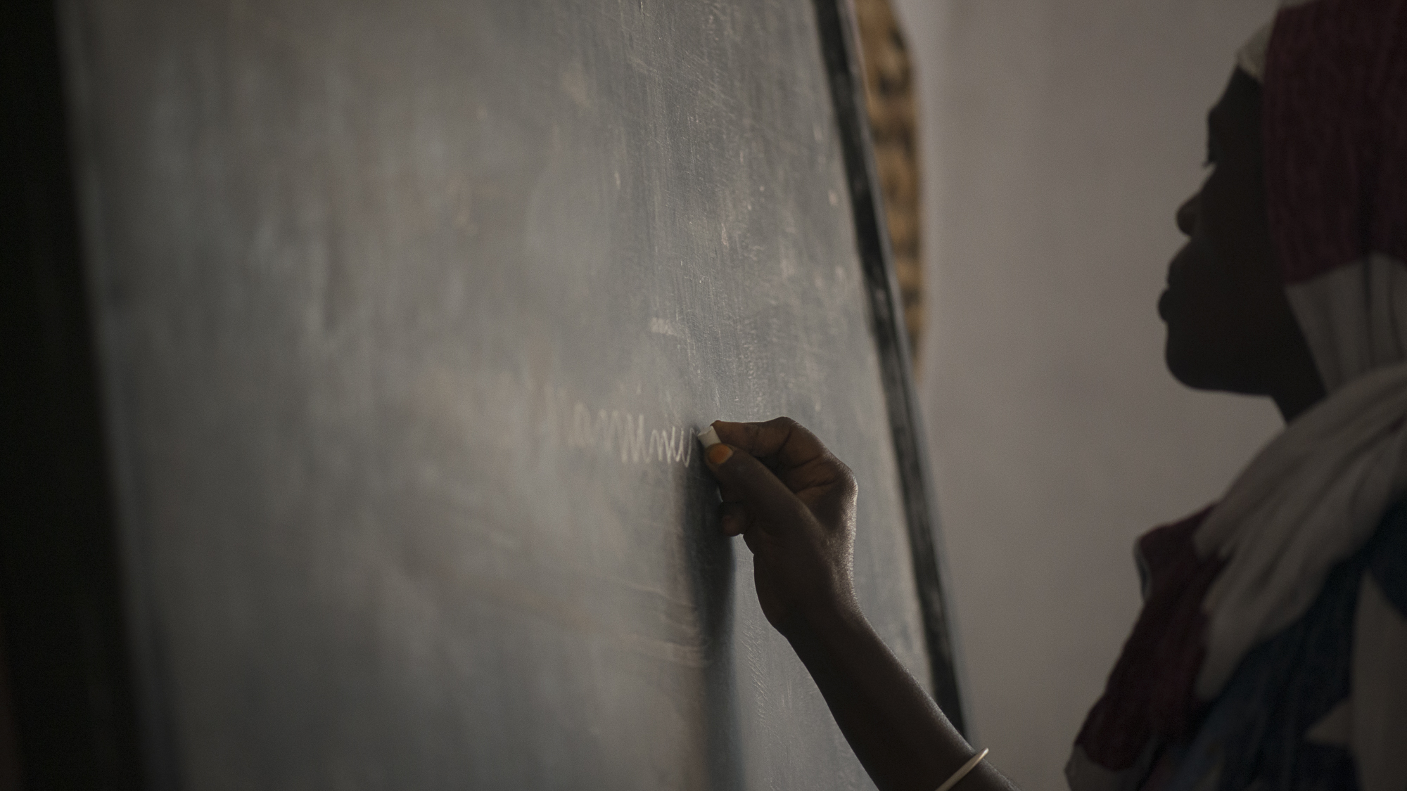A woman from Nyamirambo Women's Center practices her writing in Kinyarwanda. The center provides education to women in the neighborhood who have little to no education past primary school.