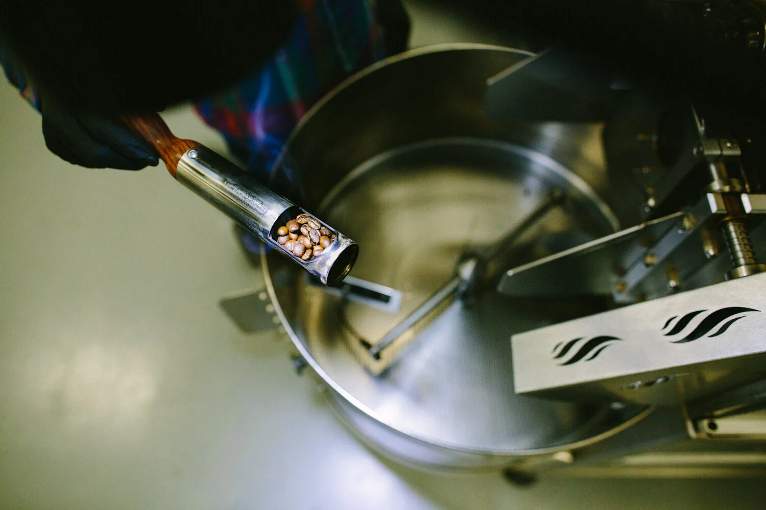 Image of man checking on his coffee roast