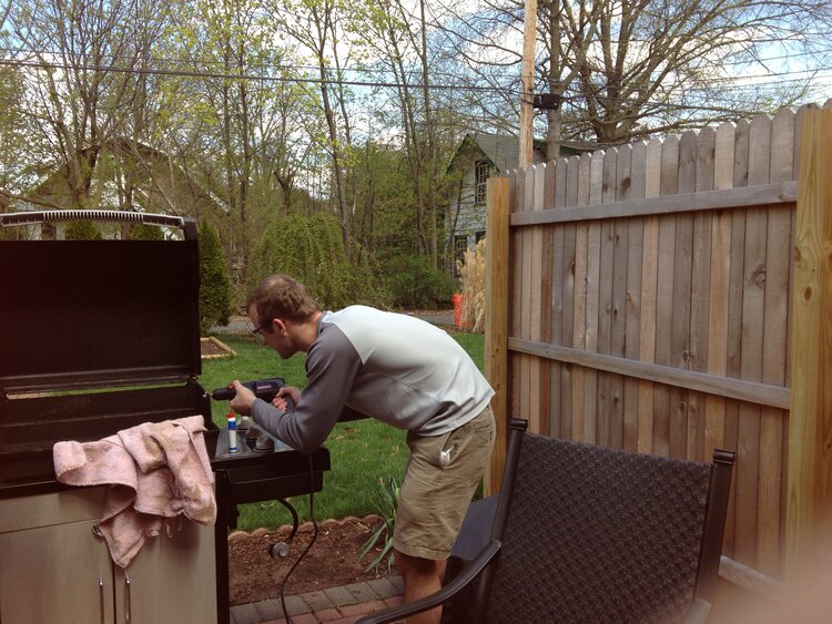 Image of Matt Adams building the company's first coffee roaster in a grill