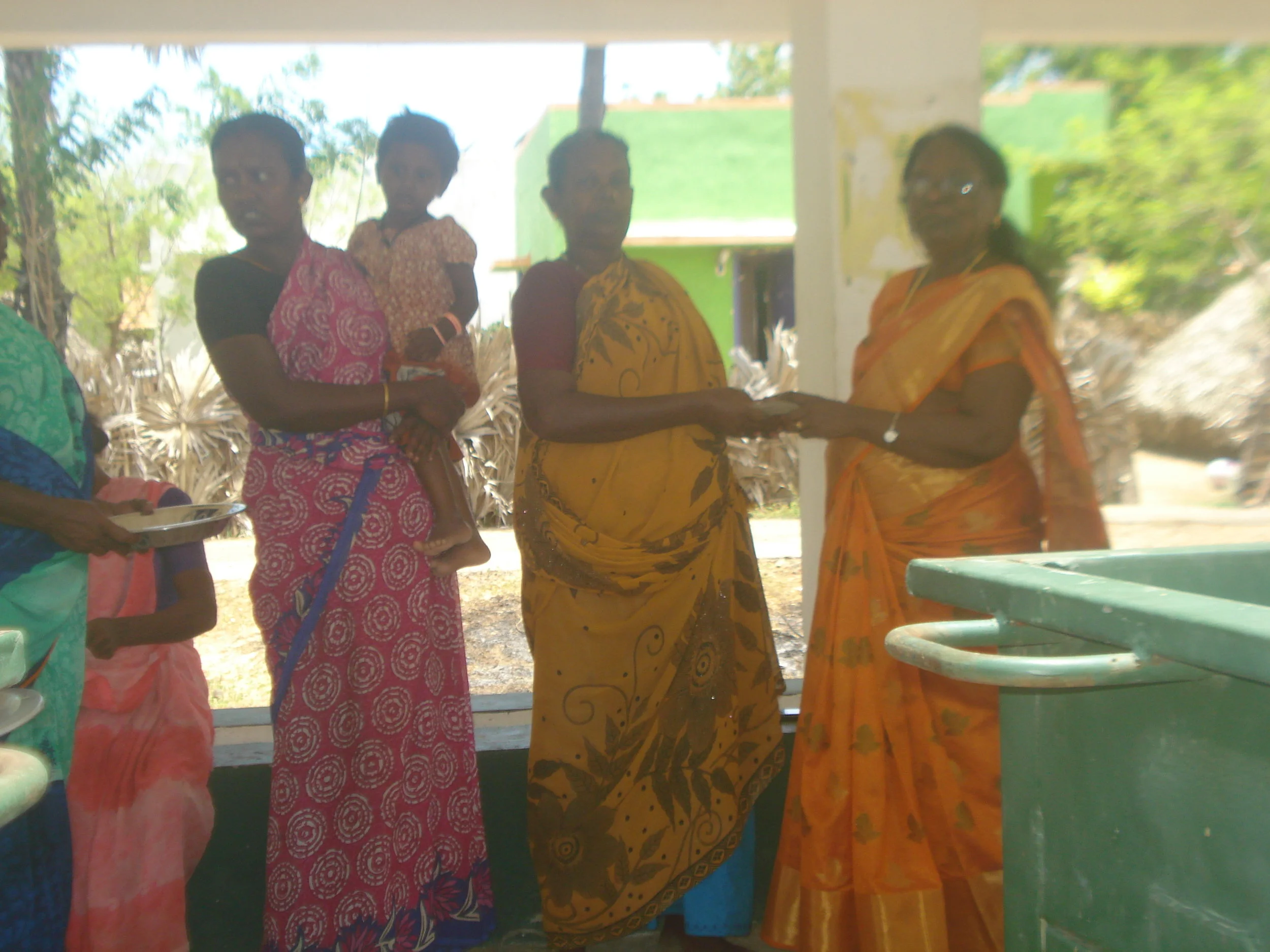 Health Coordinator Jansi Rani distributing credit assistance to Ms. Sarojamary for sea weed program.