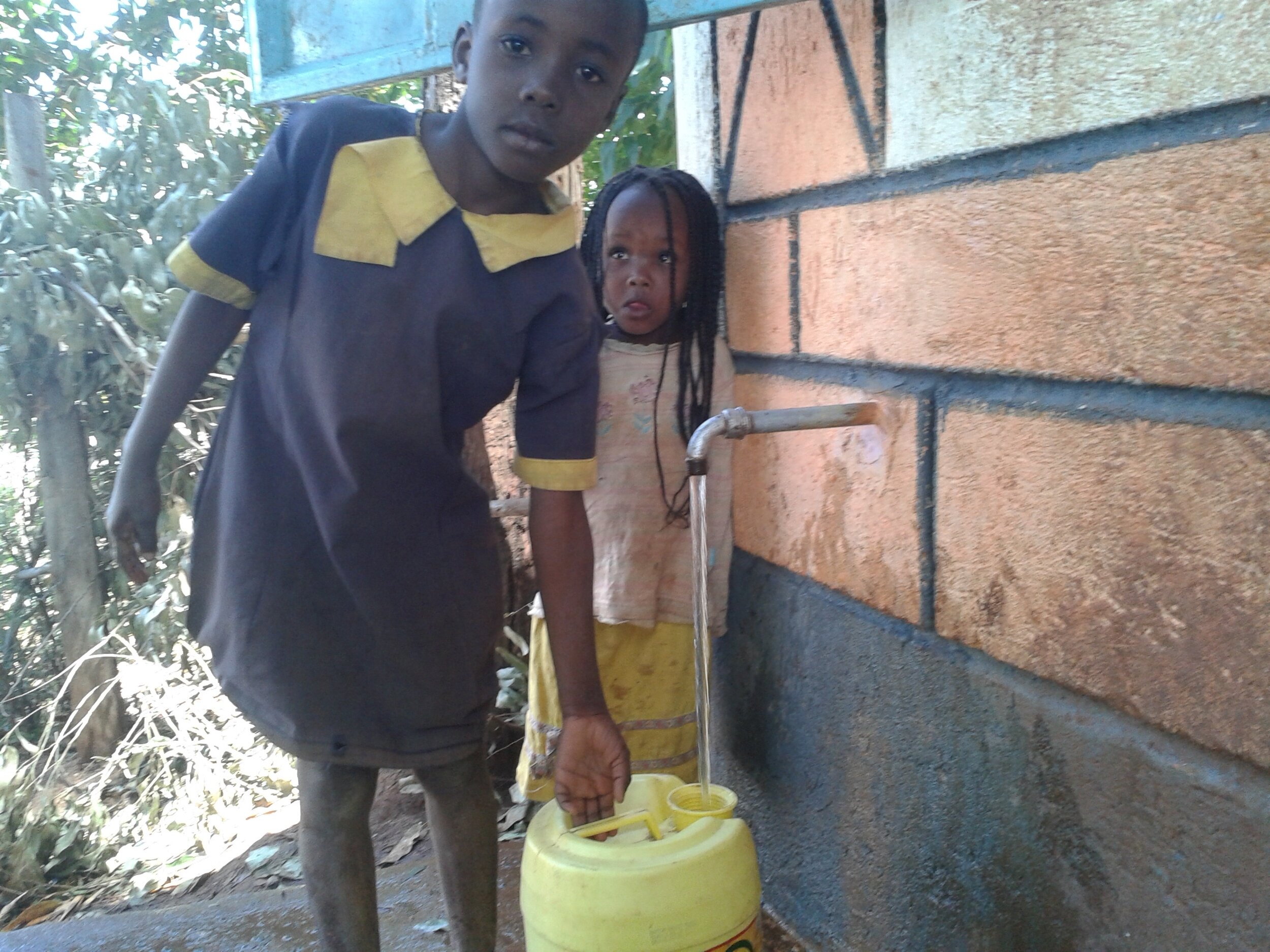 School children fetching water from completed mwoa water  kiosk.JPG