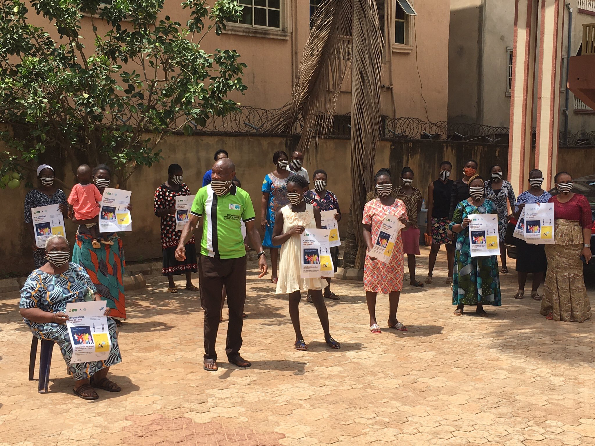 Participants in a group photograph showing off their facemasks and posters..jpg