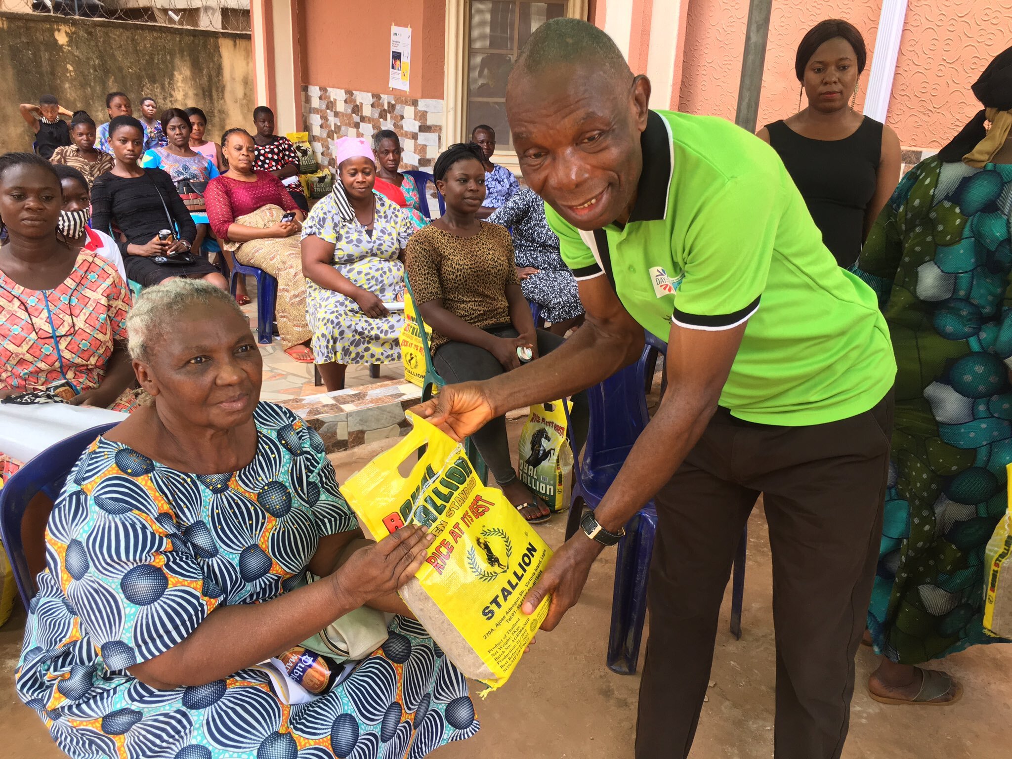 Dr Chris distributing a bag of rice to one of the beneficairies..jpg