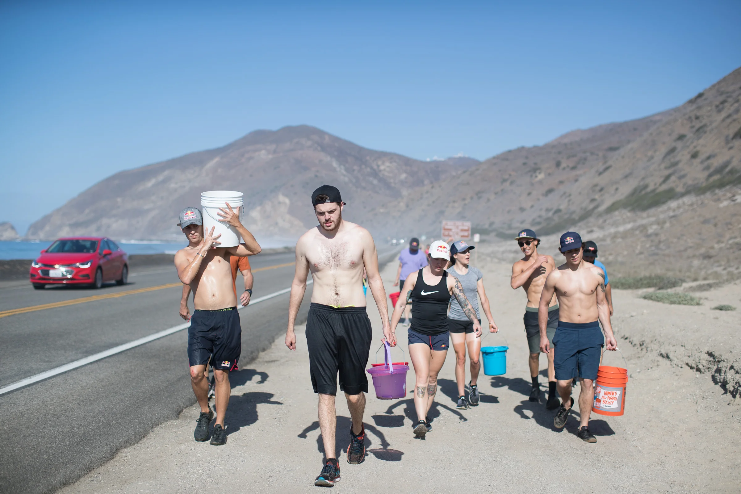 Participants carry buckets filled with water for a Seal training exercise during Performing Under Pressure, in Malibu, California October 5 2018