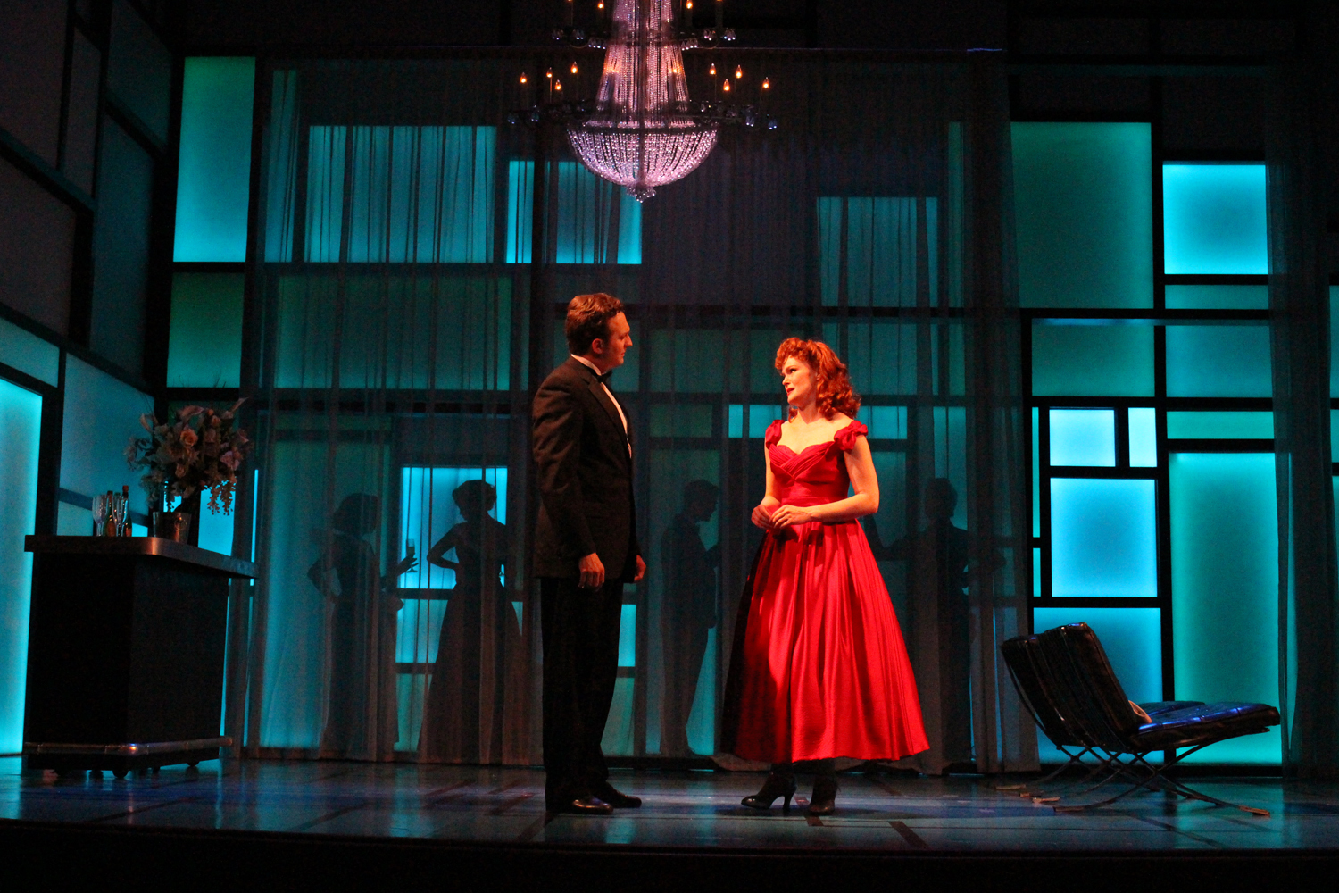 ELLA SAYS GOODBYE TO JEFF IN LARRY'S PENTHOUSE. THE SPACE UPSTAGE OF THE WINDOW/SHEER CURTAINS WAS PLAYED AS A BALCONY