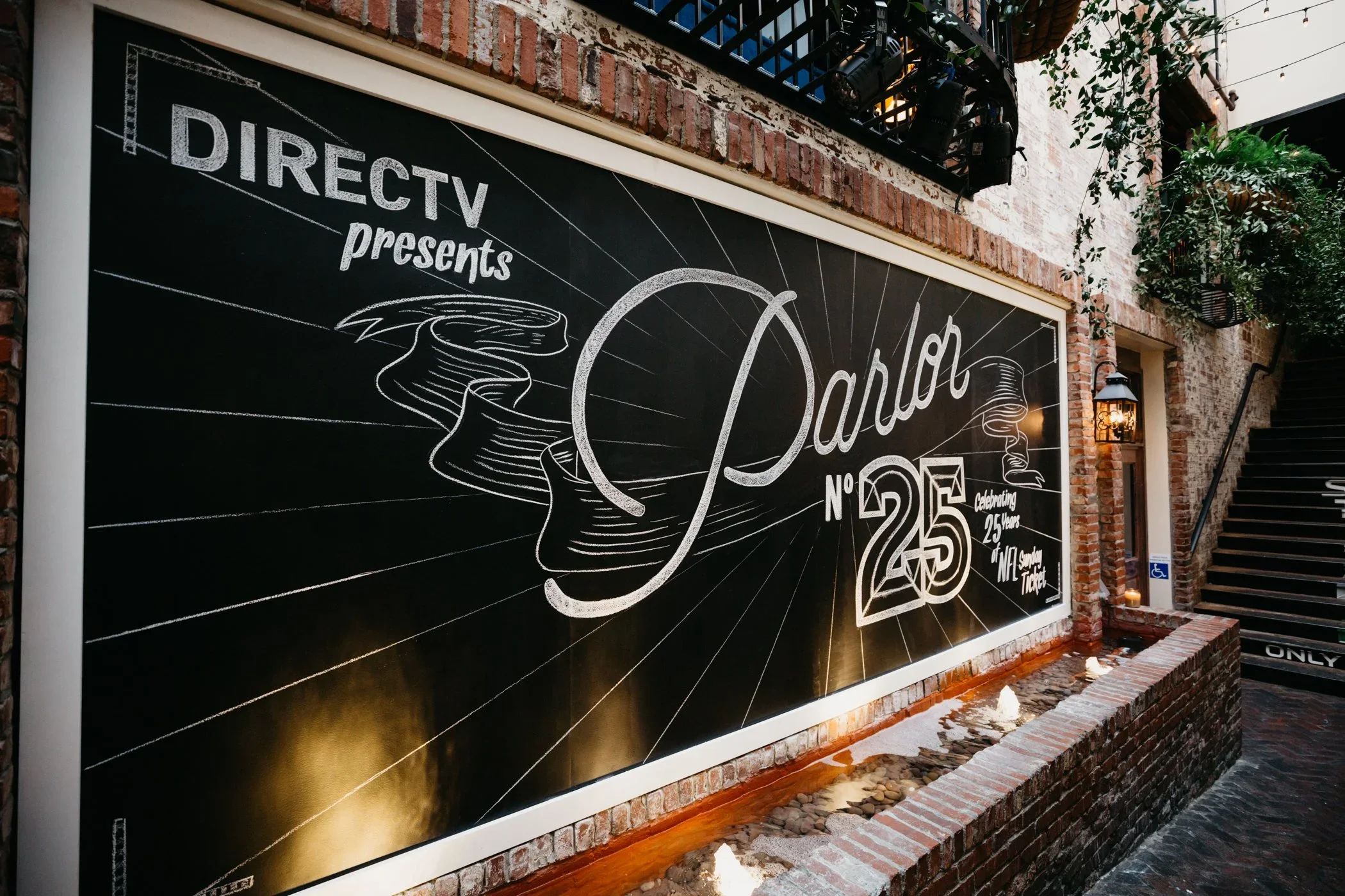 Large branded mural wall with custom graphics for outdoor event activation and guest photo moment.