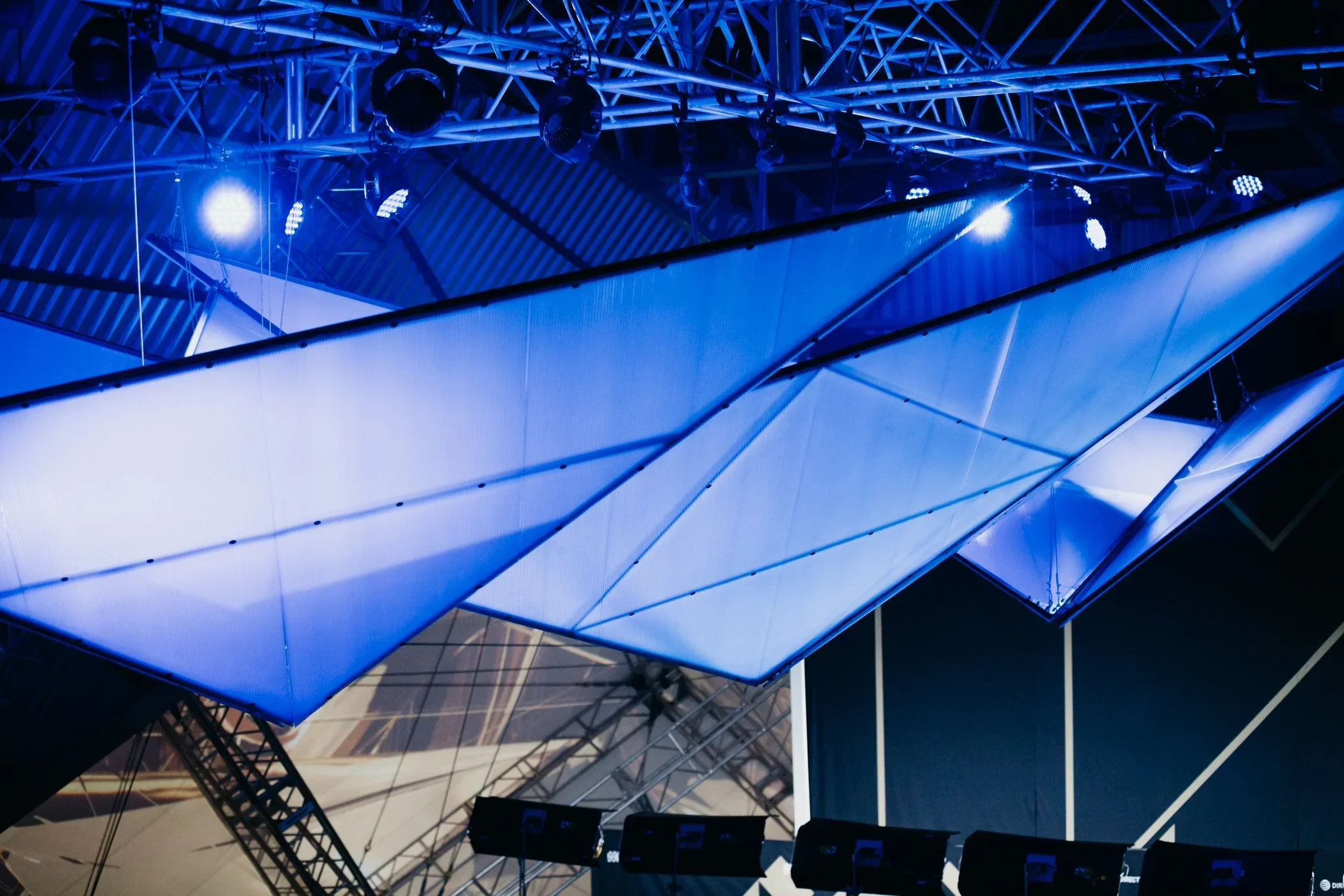Geometric scenic ceiling installation with illuminated panels.