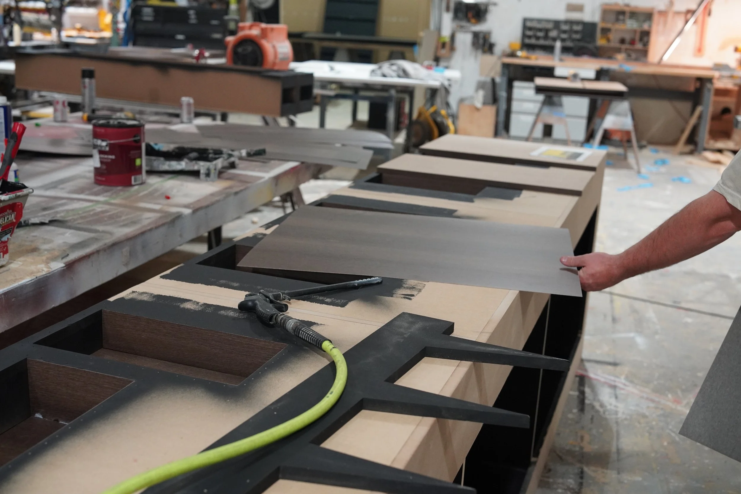 Material samples and finish options being reviewed in the GREENE fabrication shop.