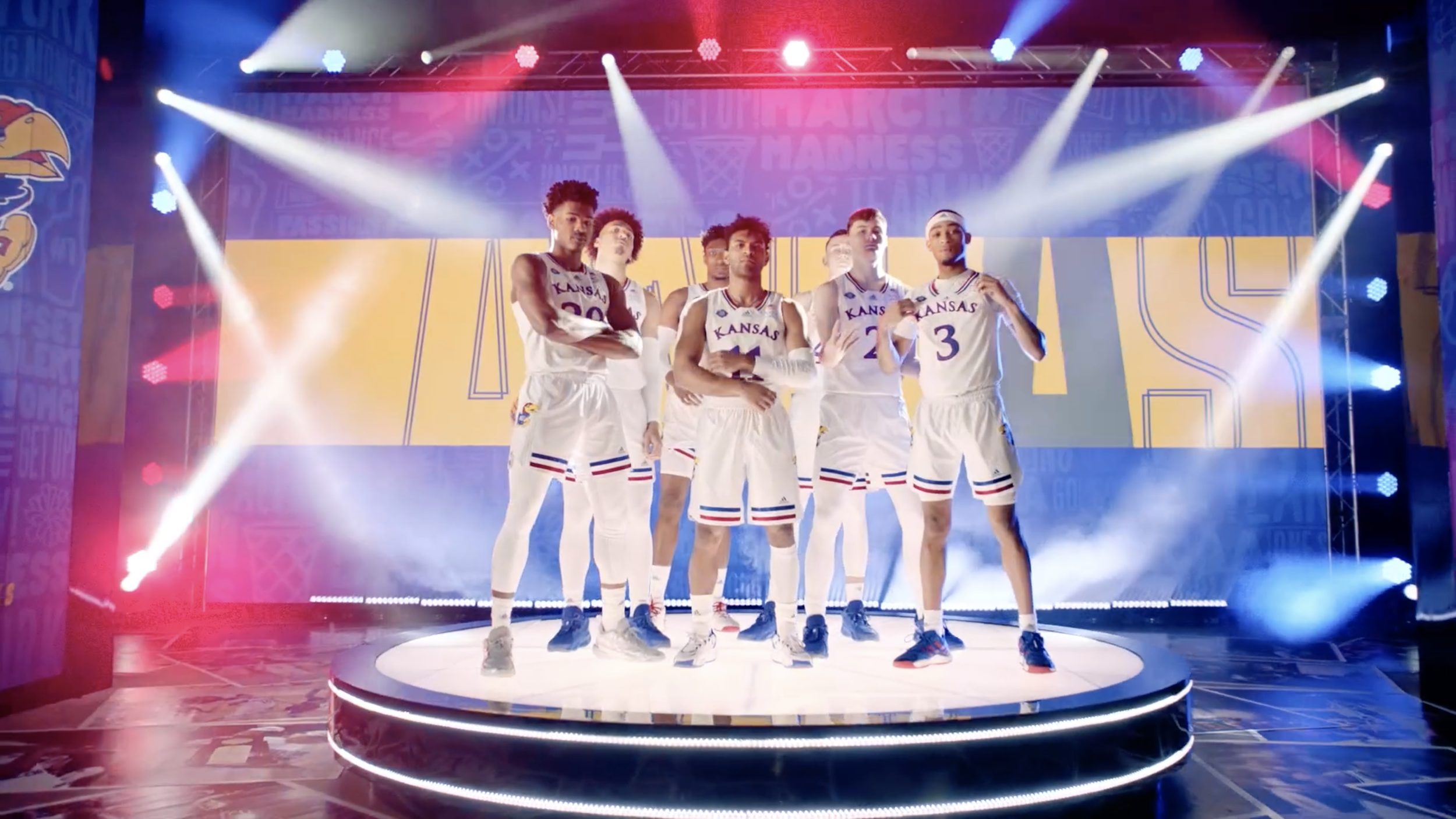 Basketball team reveal on illuminated circular stage with branded event graphics and lighting.
