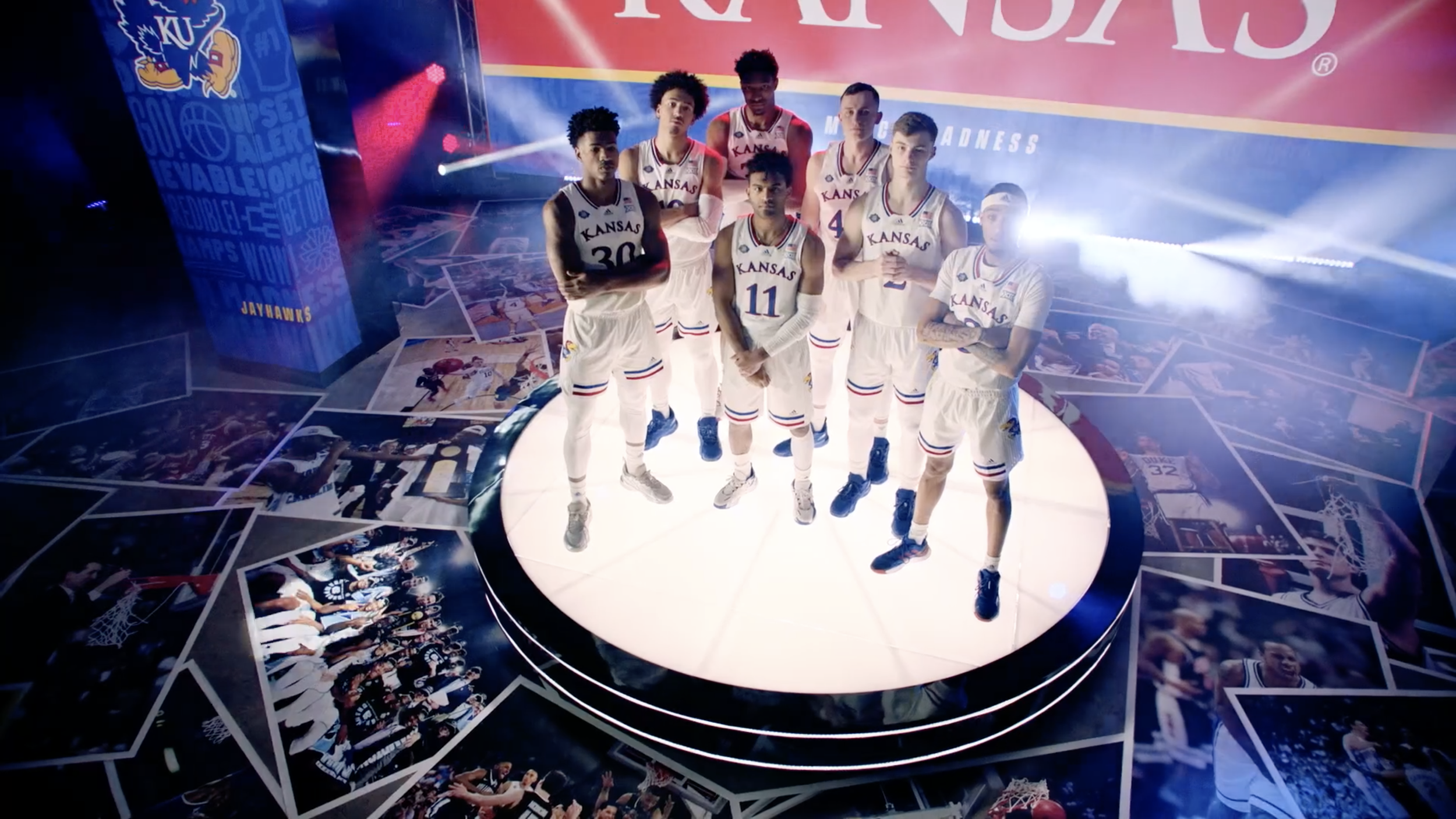 Overhead view of basketball team presentation with custom circular stage and branded floor graphics.