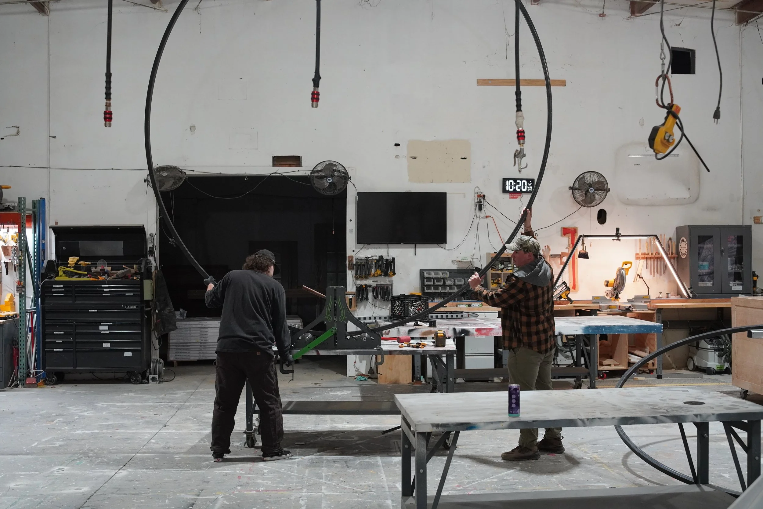 Wide view of the GREENE fabrication shop with team members working on custom builds.