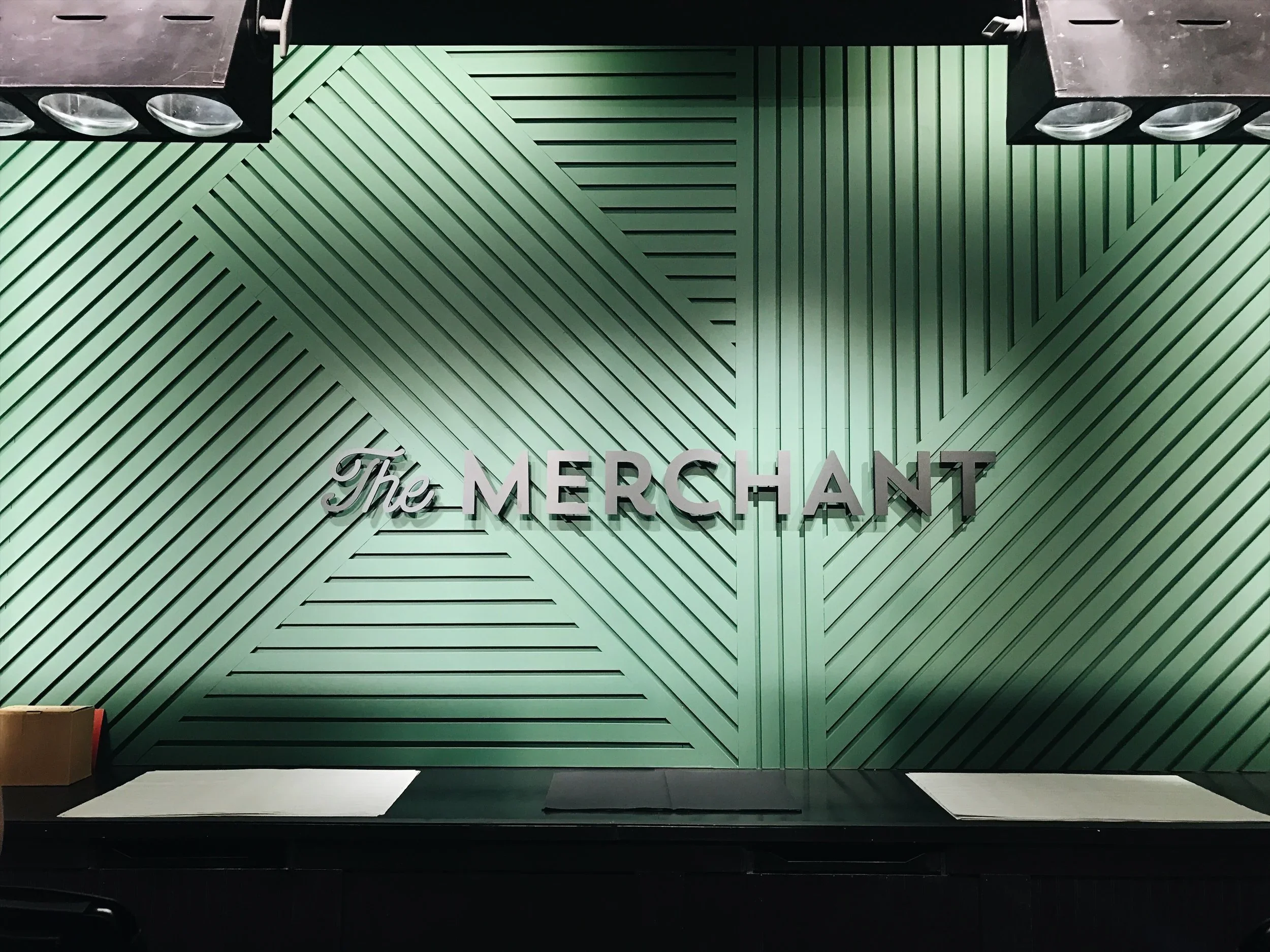 Custom restaurant interior wall with dimensional signage, painted scenic panels, and branded hospitality design.