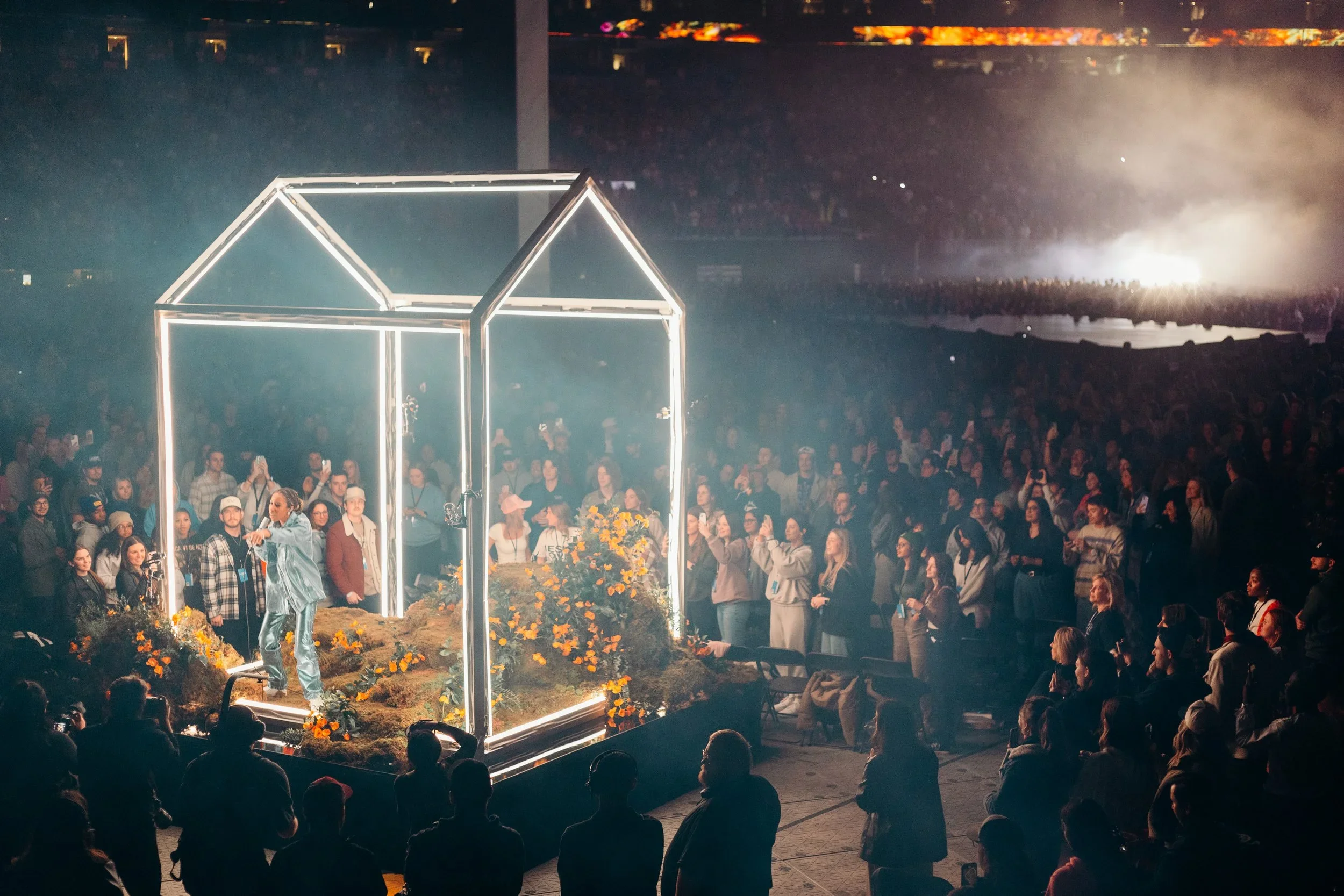 Illuminated house-shaped structure built for a live event environment.