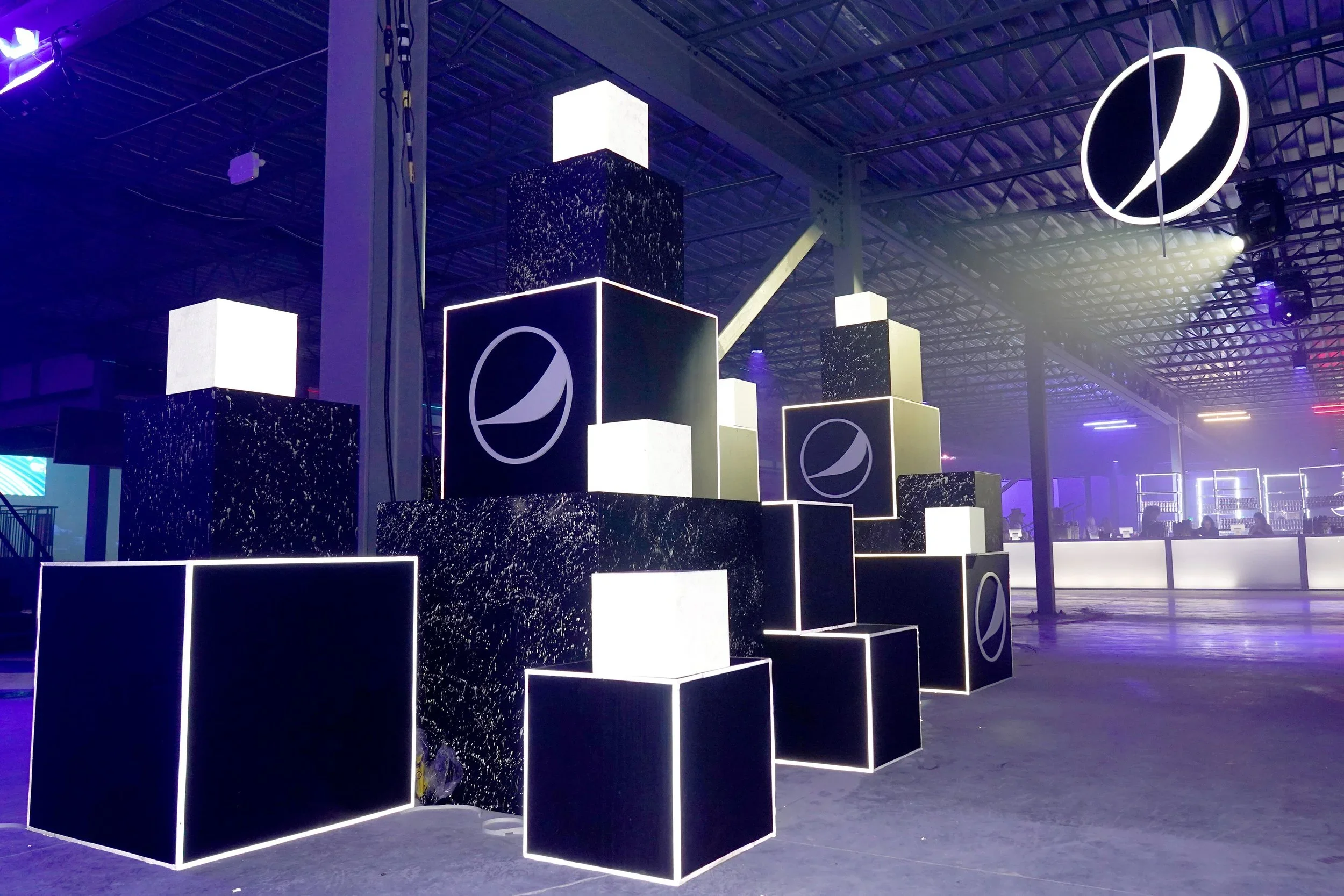 Branded cube installation with illuminated displays for immersive event environment.