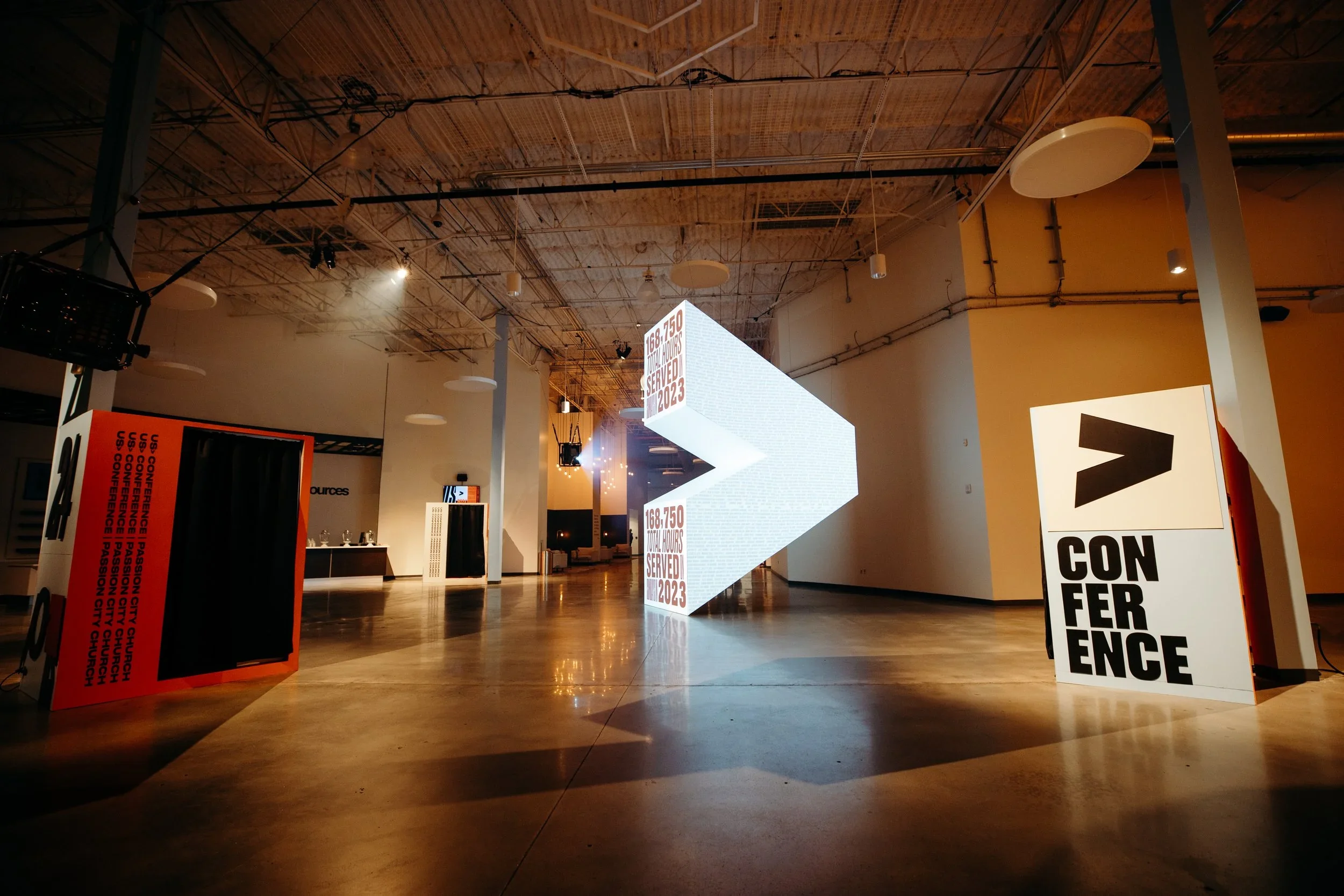 Conference wayfinding display with custom scenic structures and lighting.