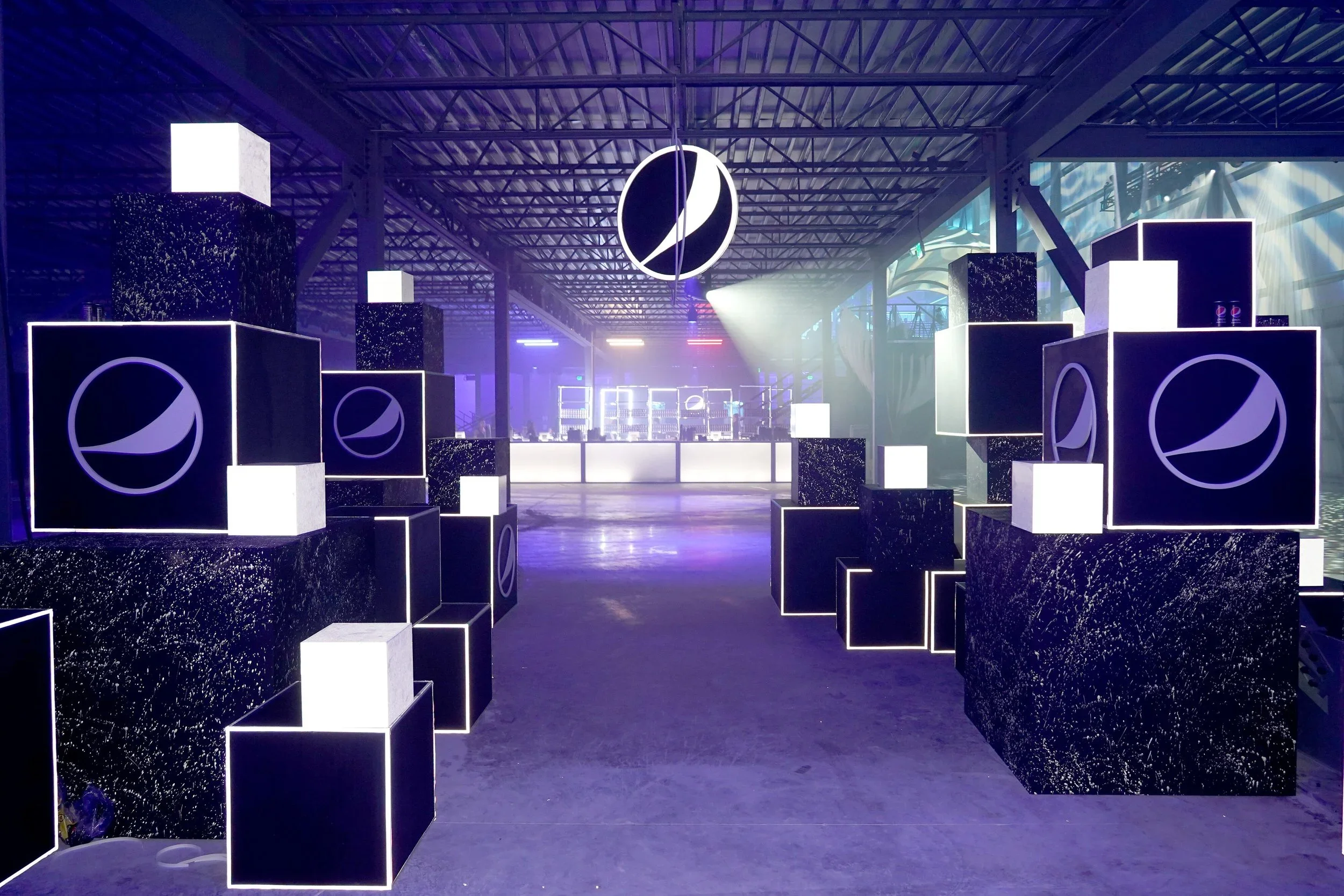 Large-scale branded event environment with illuminated cube displays and scenic fabrication.