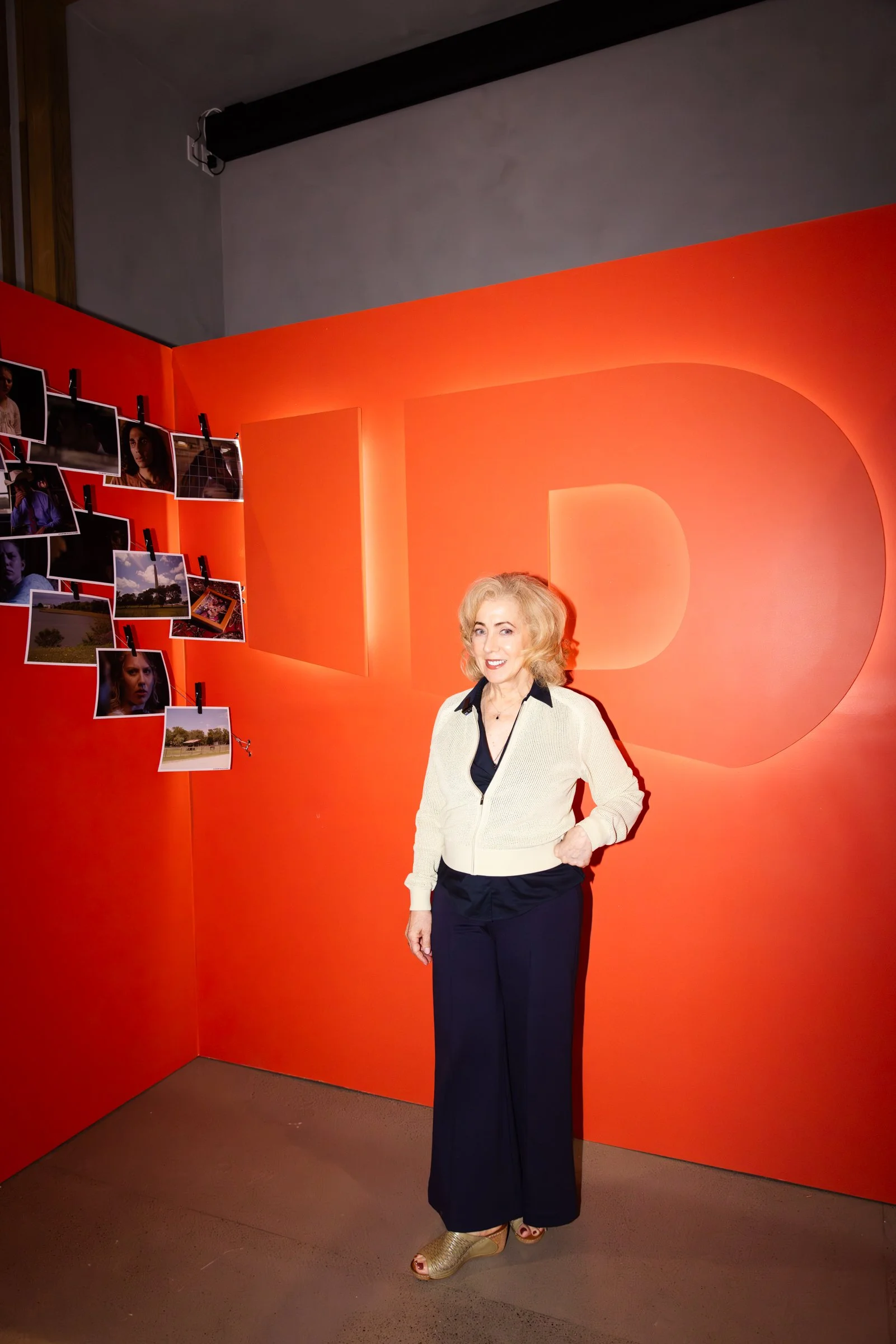 Branded photo moment with dimensional logo wall and custom red scenic backdrop.