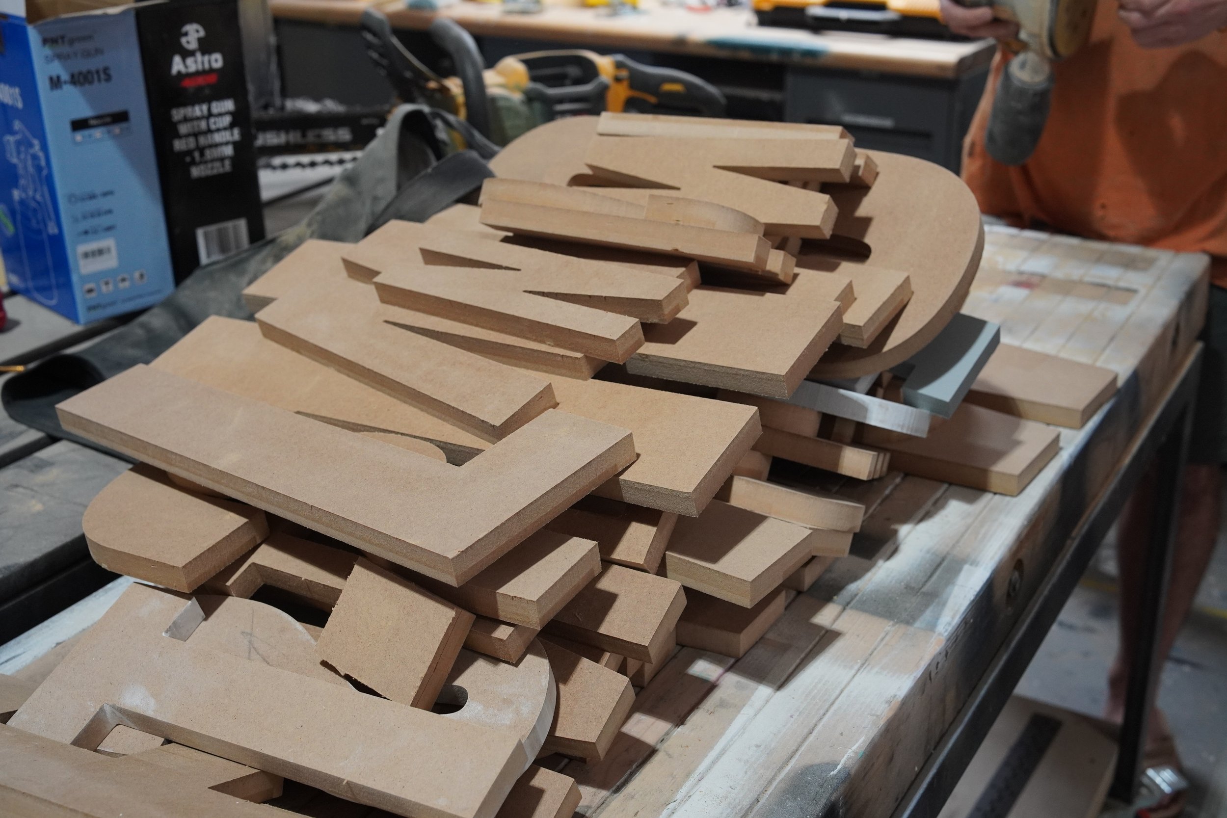 CNC-cut wood pieces and fabrication materials prepared for a custom scenic build at GREENE.
