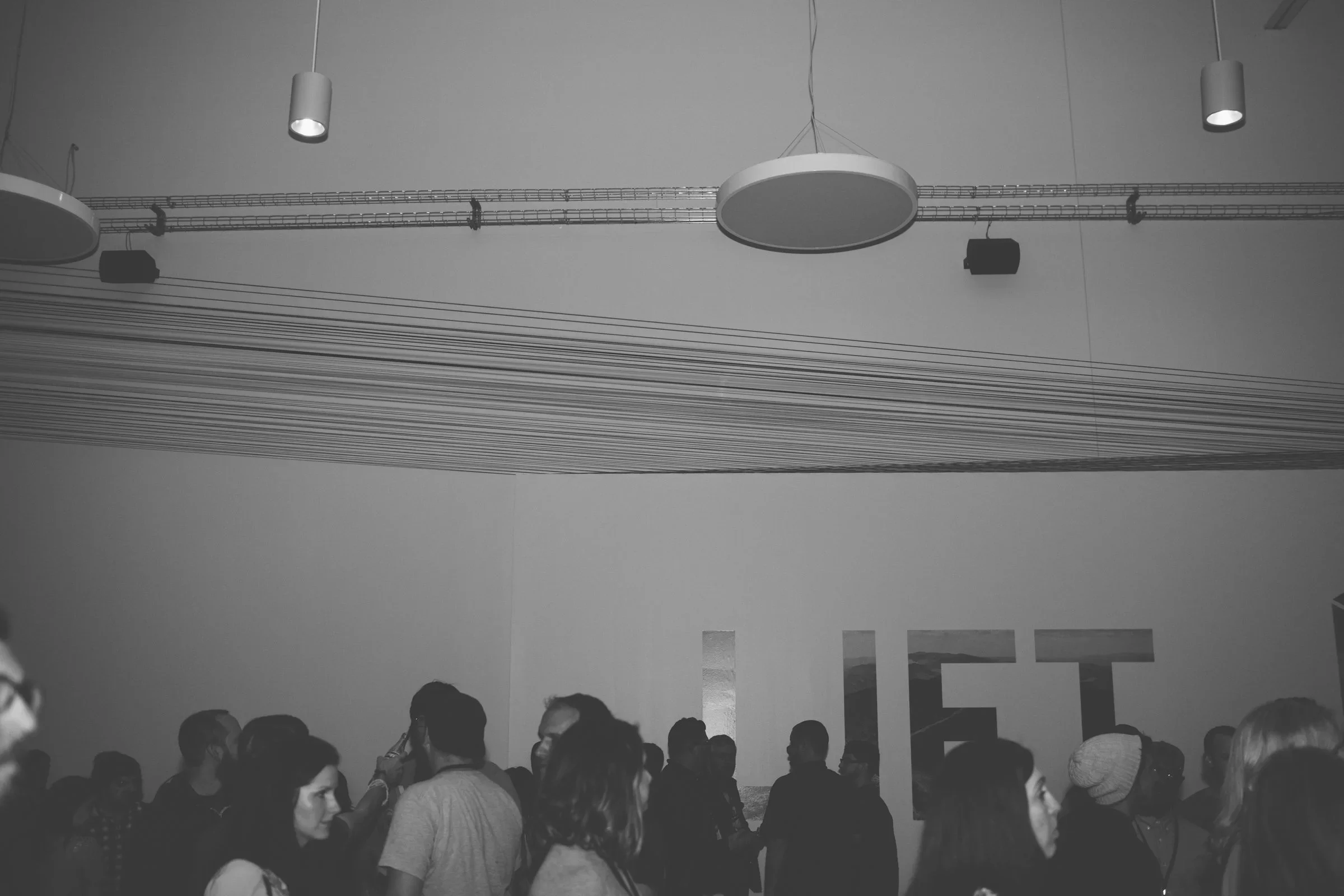 Suspended linear scenic installation with custom lighting for an immersive event environment.