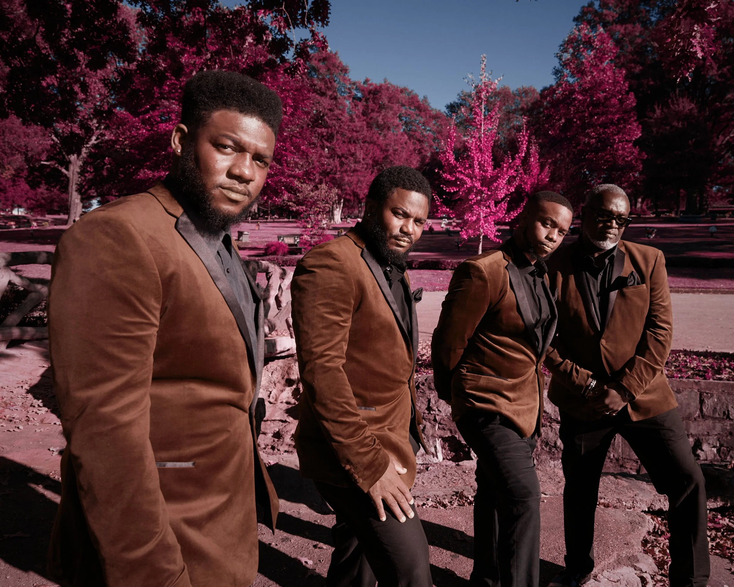 Four performers in coordinated suits
