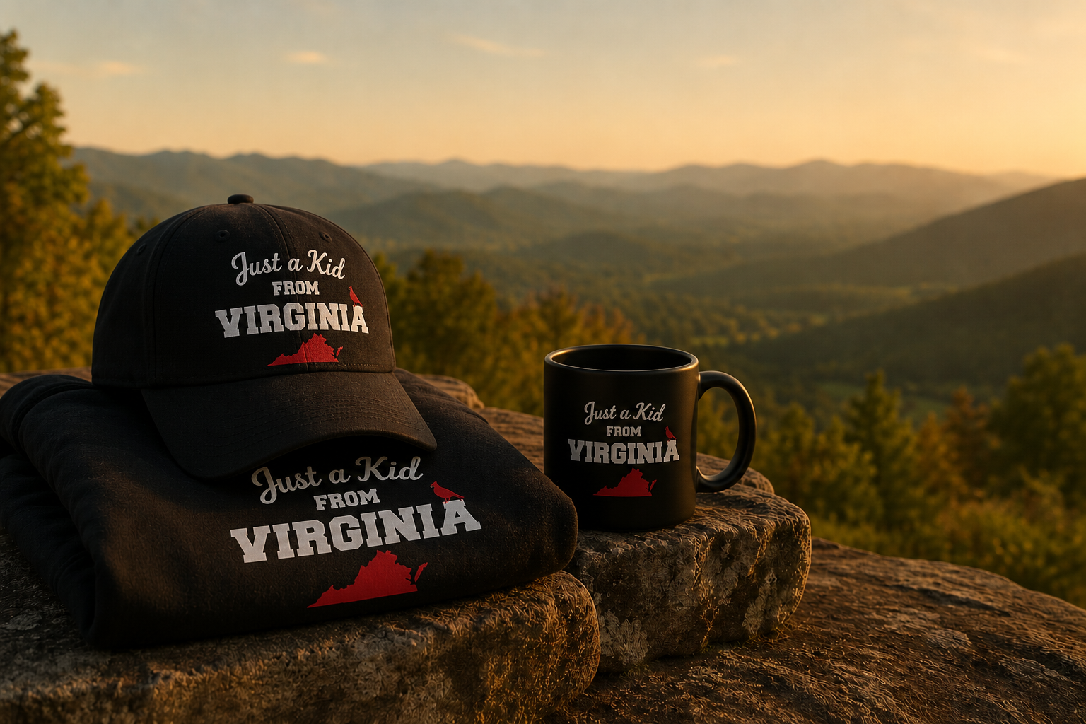 A black baseball cap, a black hoodie, and a black mug with the text "Just a Kid from Virginia" and an outline of Virginia and a red bird, set on a rock overlooking a scenic mountainous landscape during sunset.